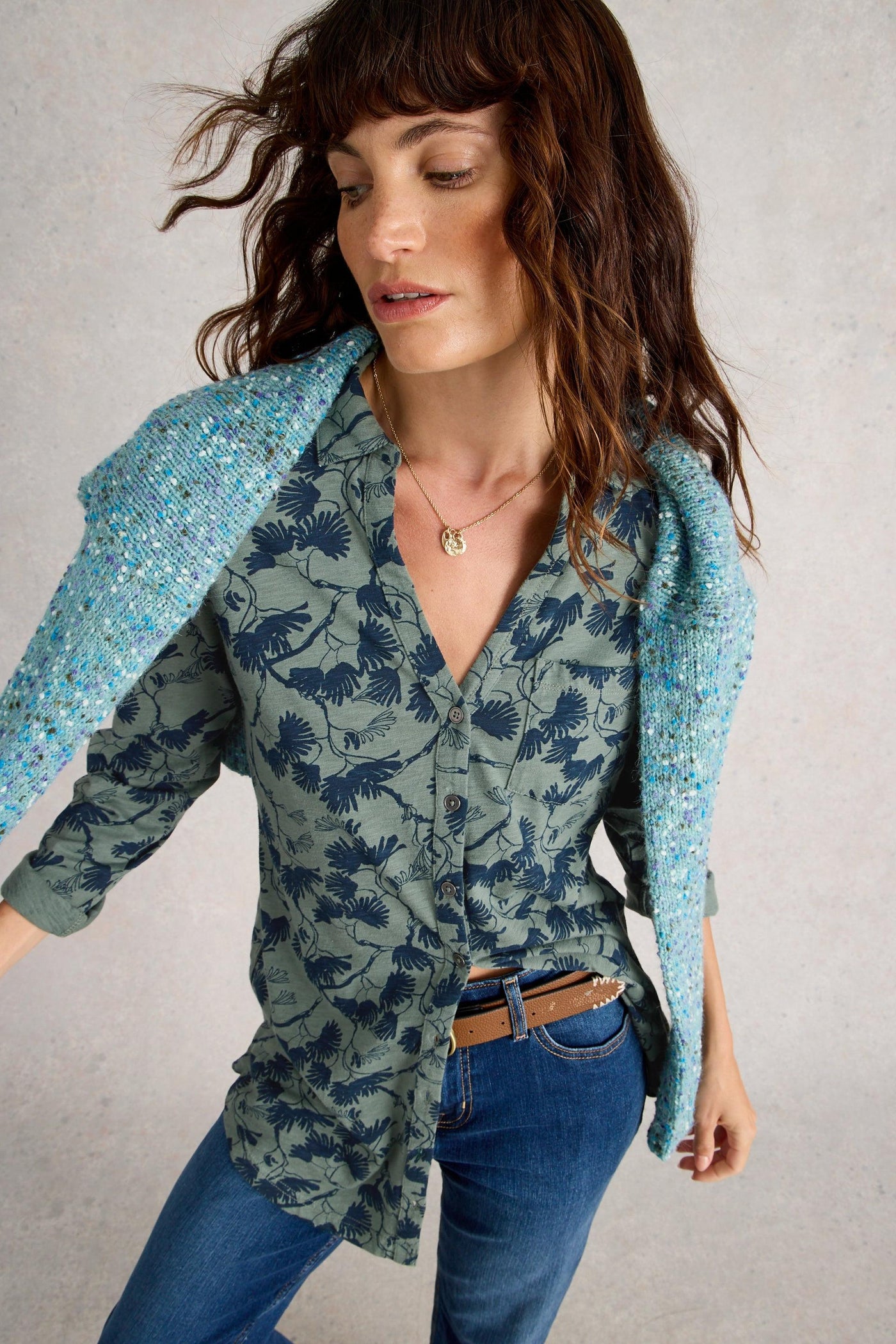 Model wearing green longline cotton tunic with blue floral print,with collar, long sleeves, and classic fit