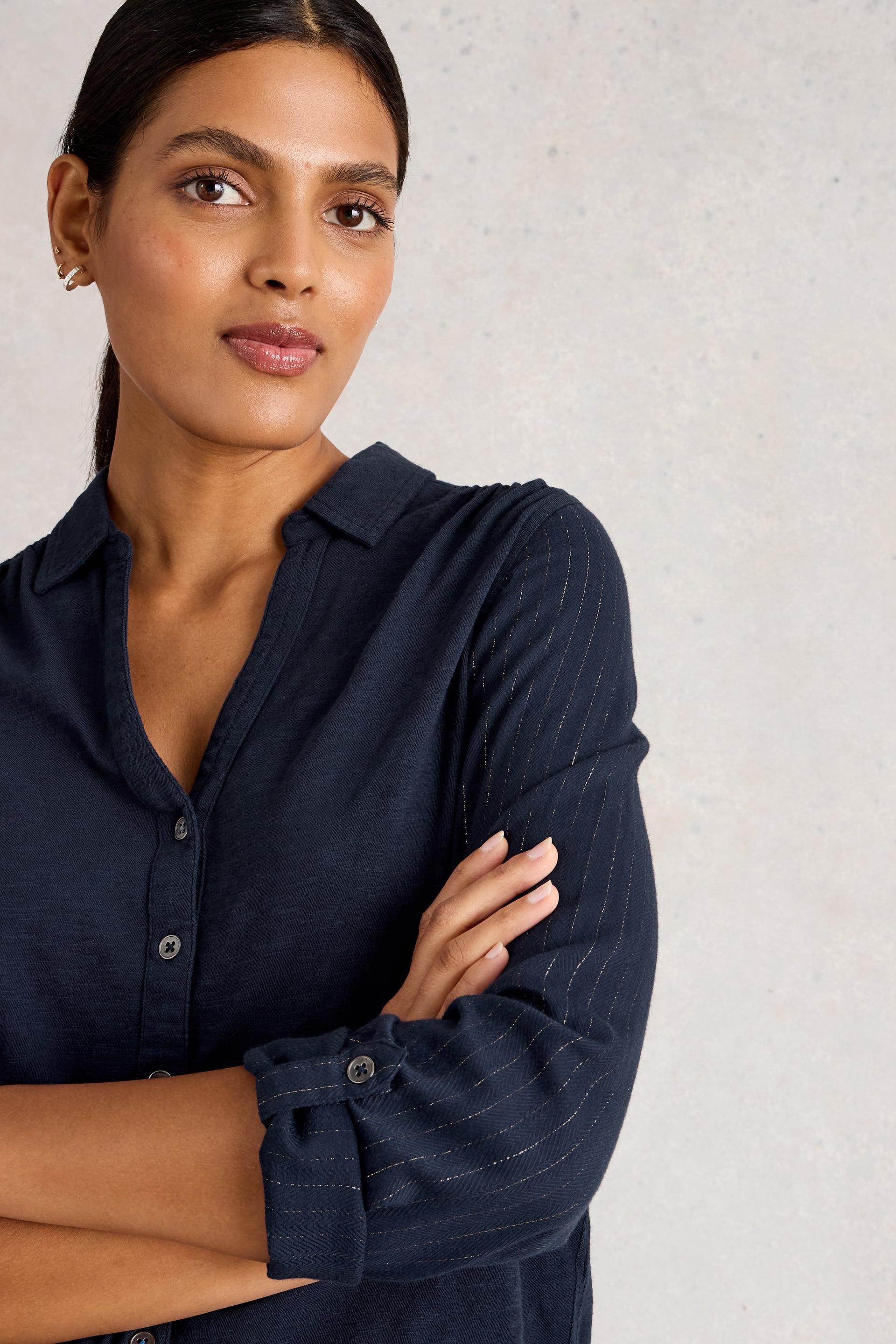 Woman wearing a navy blue organic cotton shirt against a light background