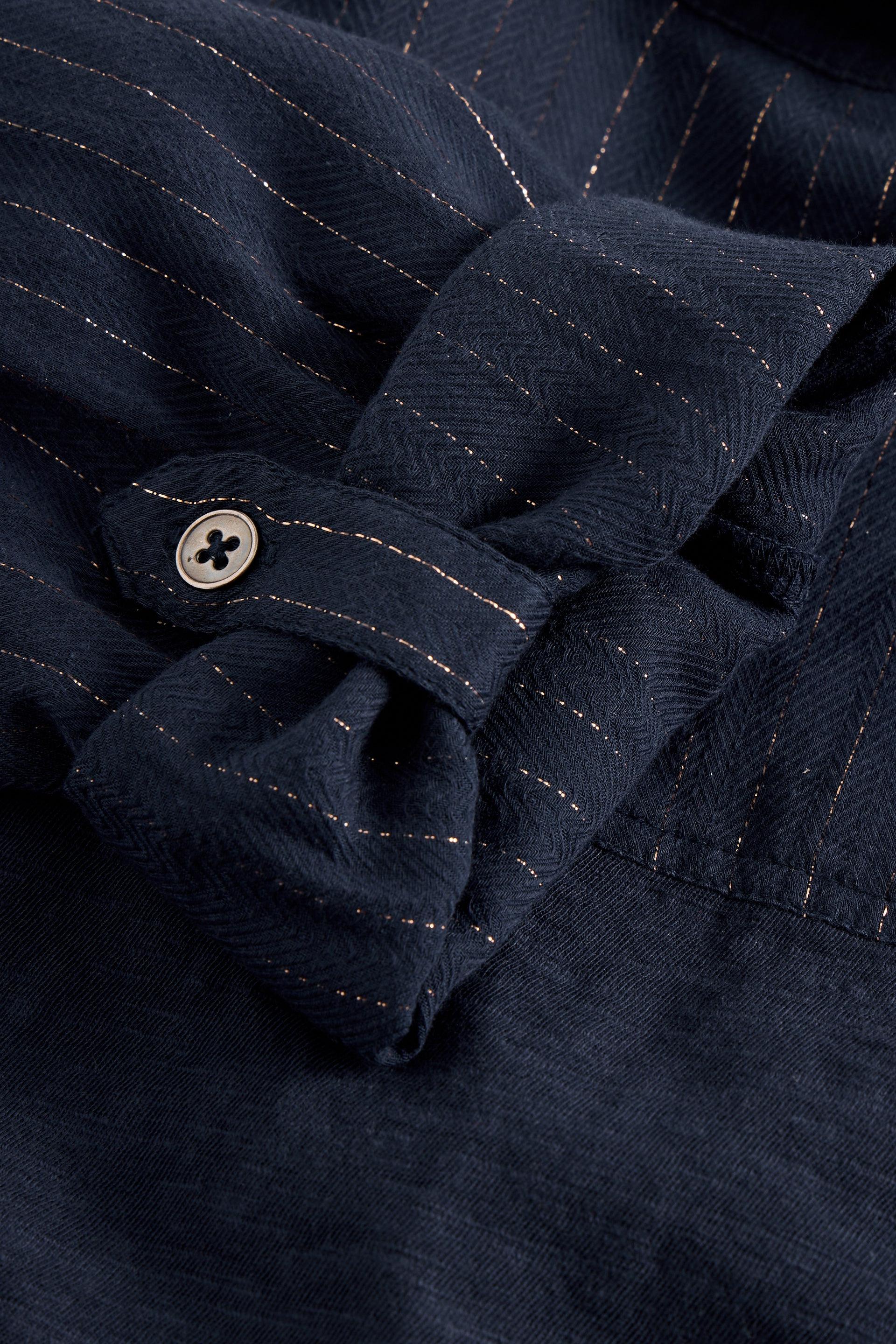 Close-up of a navy blue fabric with a button and stitching details