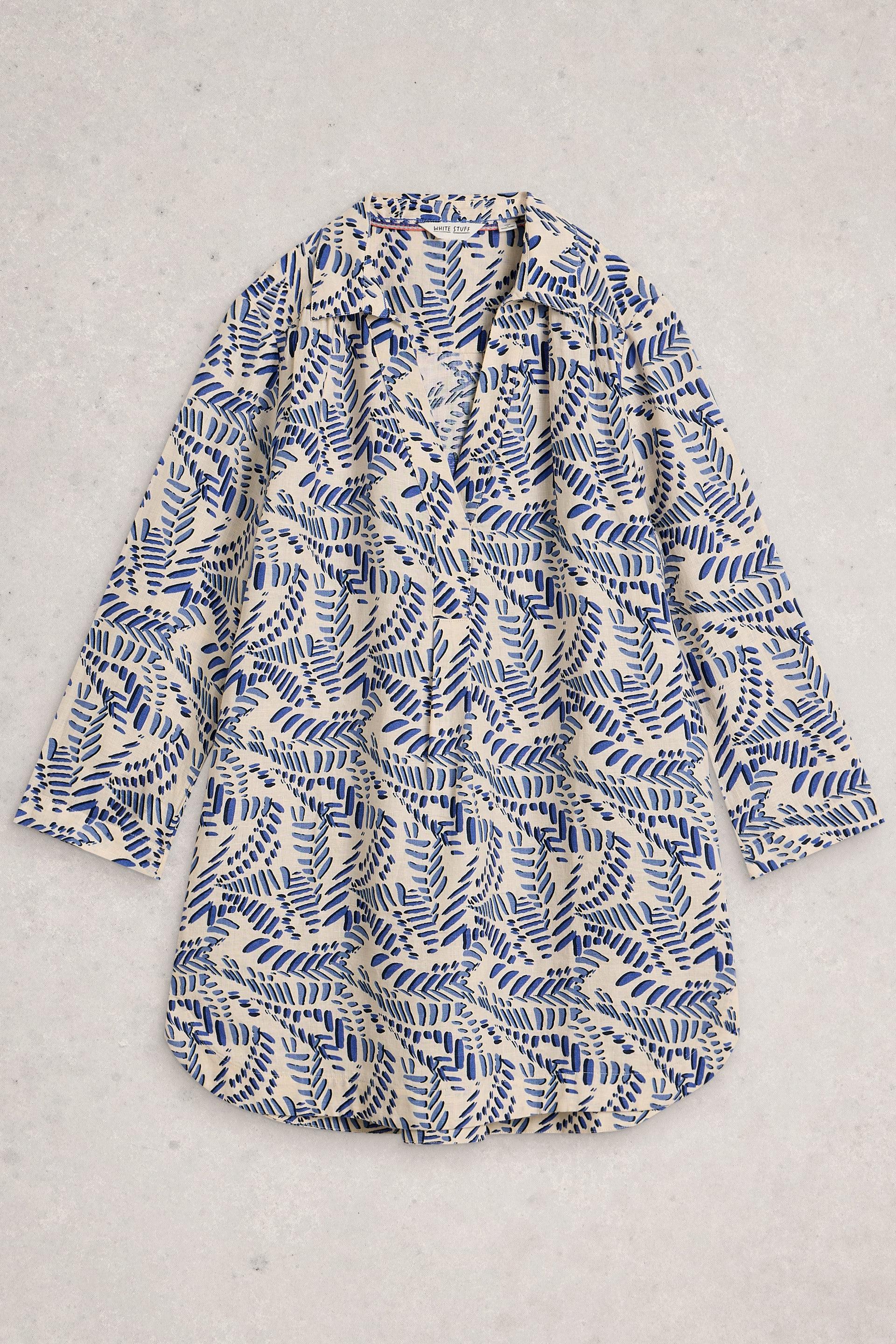 Blue and white patterned tunic on a light gray background