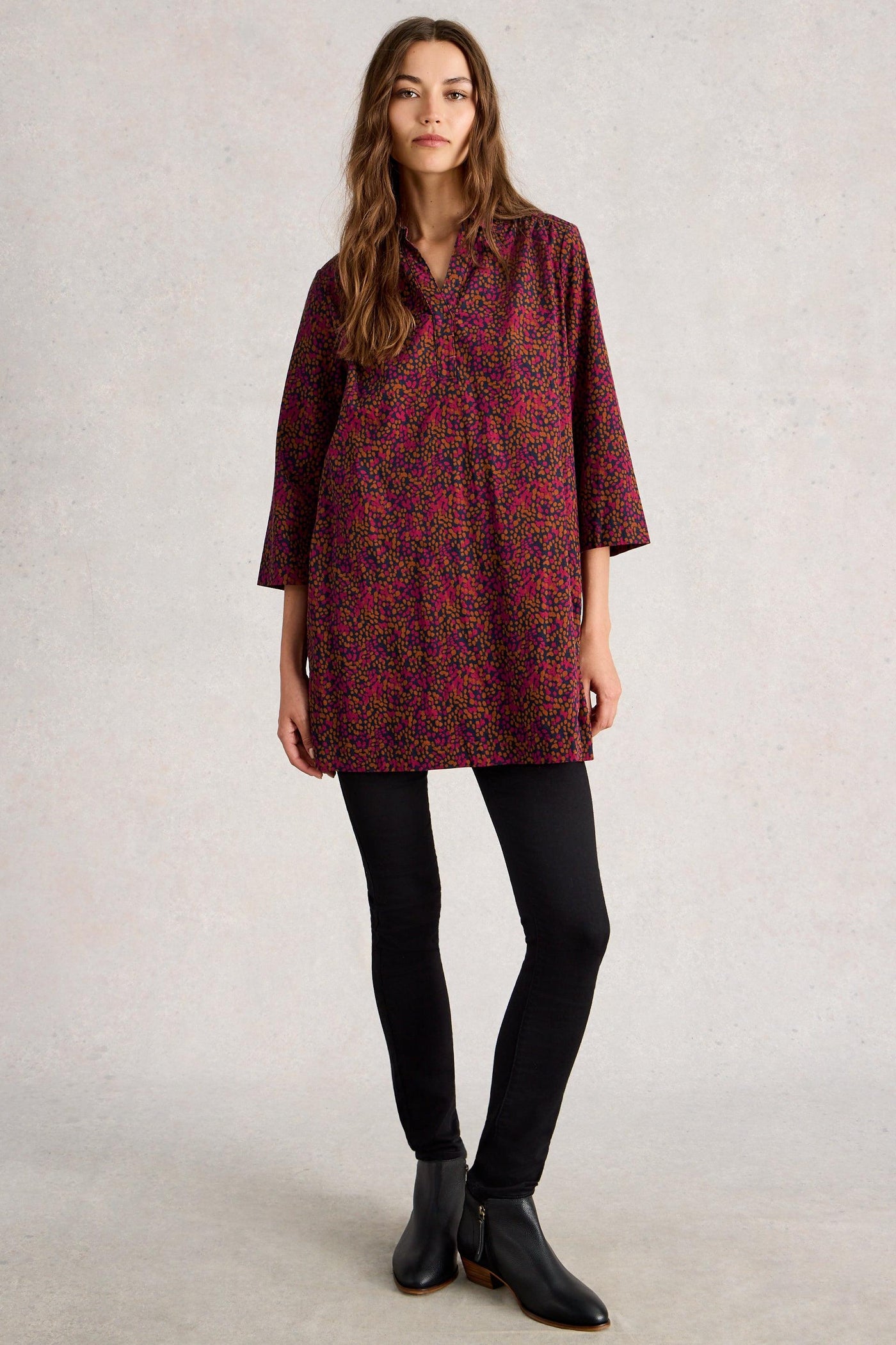 Woman wearing cord organic cotton tunic, styled with a black leggings and black leather boots
