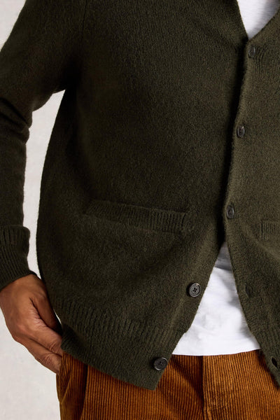 Close up of ribbed hem and green buttons on wool cardigan