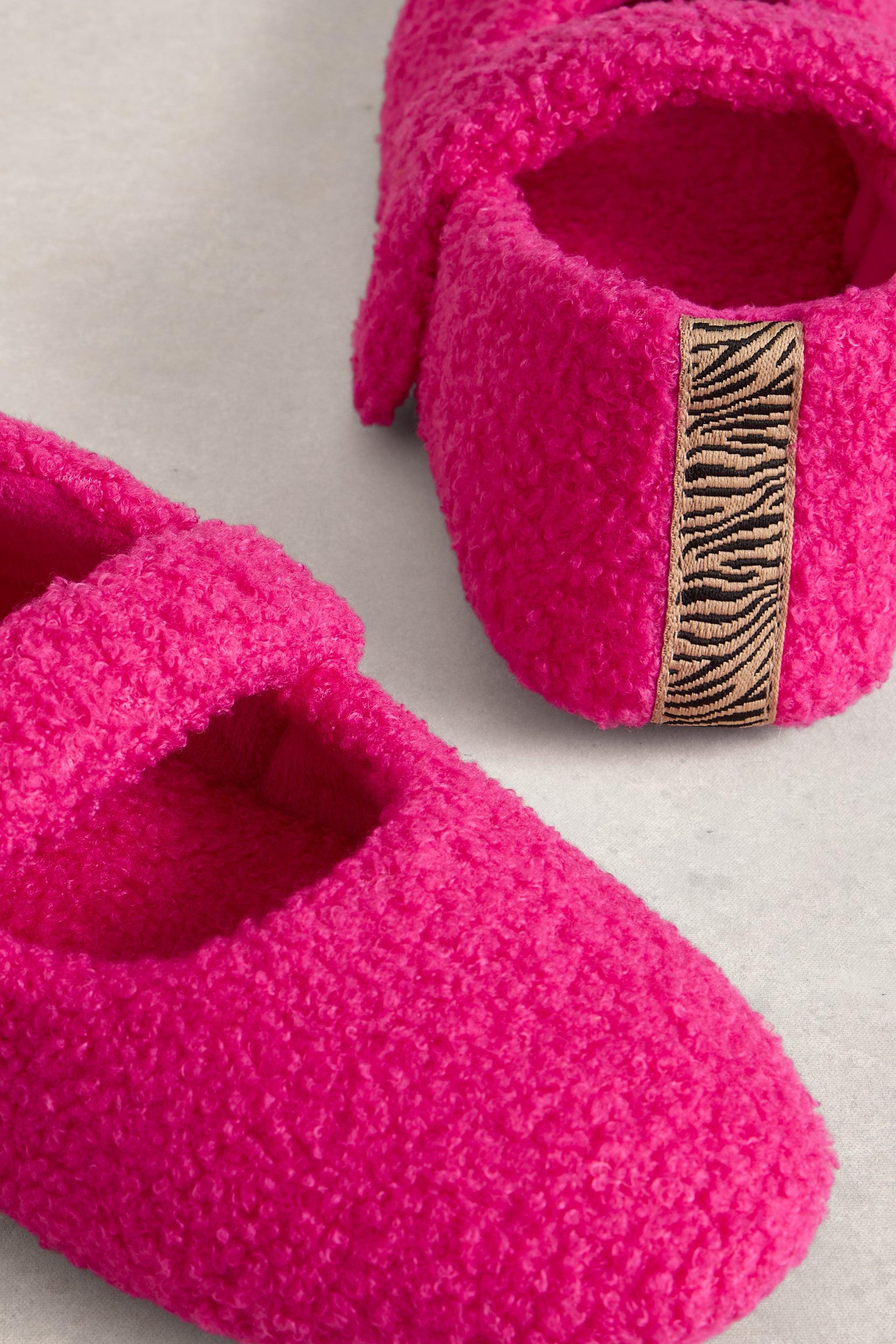 Pink slippers with a zebra pattern strap on a light background