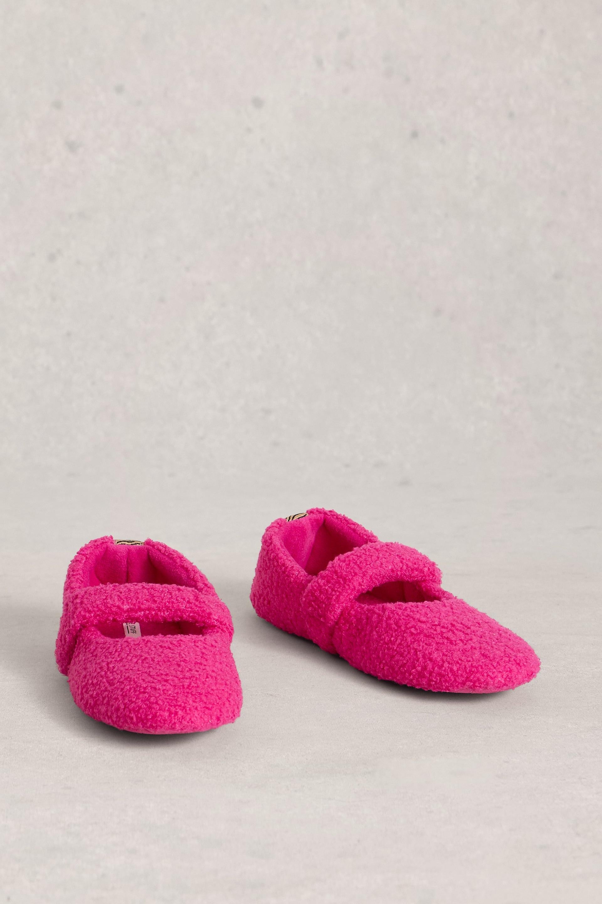 Pair of pink slipper shoes on a light gray background