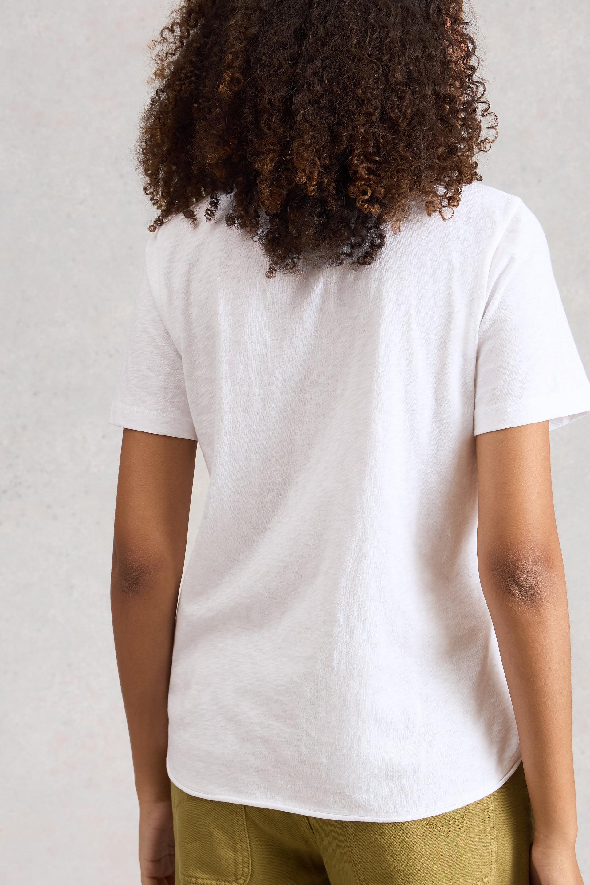 Person wearing a plain white cotton t-shirt against a neutral background