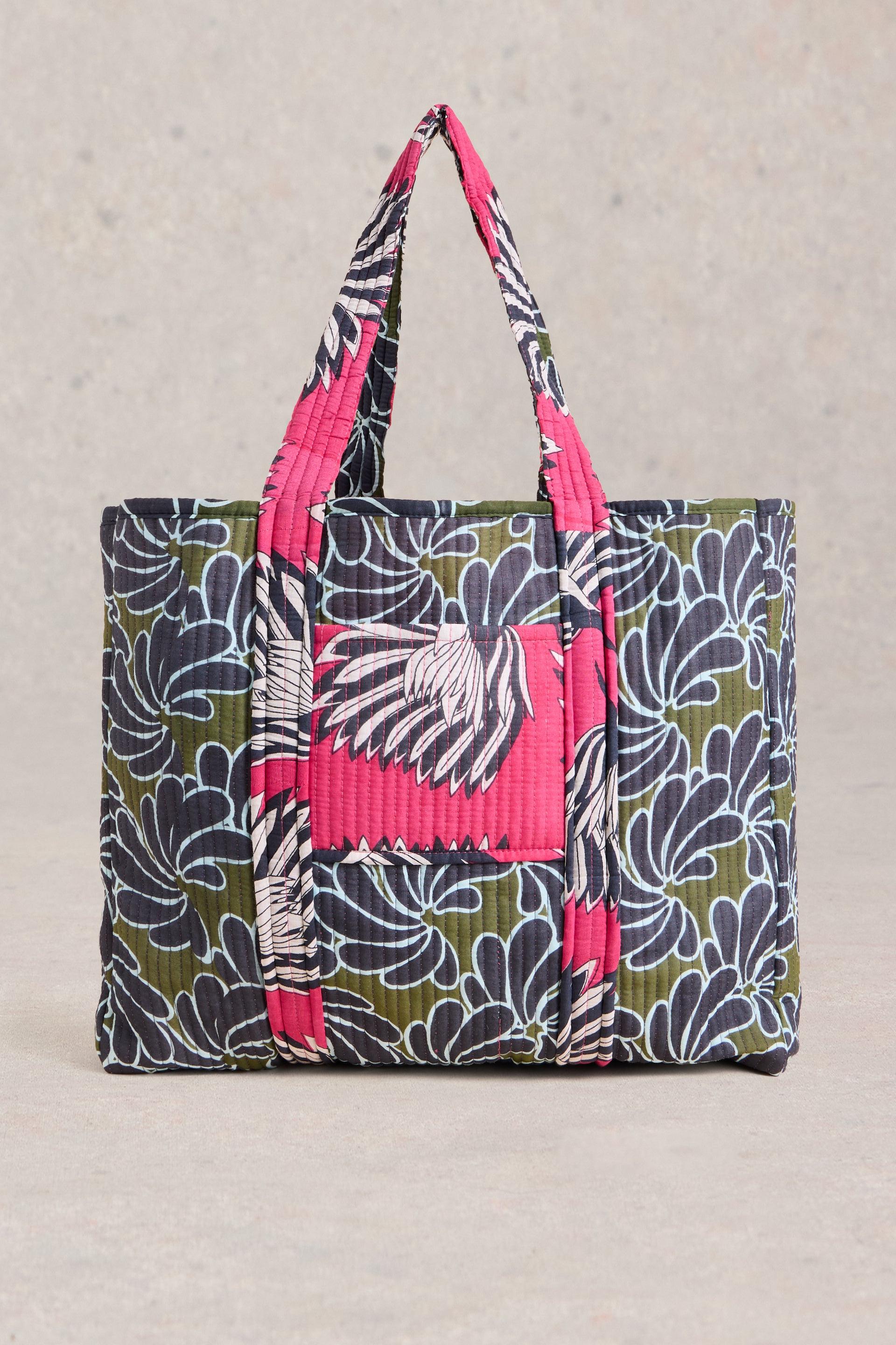 Side view of large cotton beach bag with floral detail.