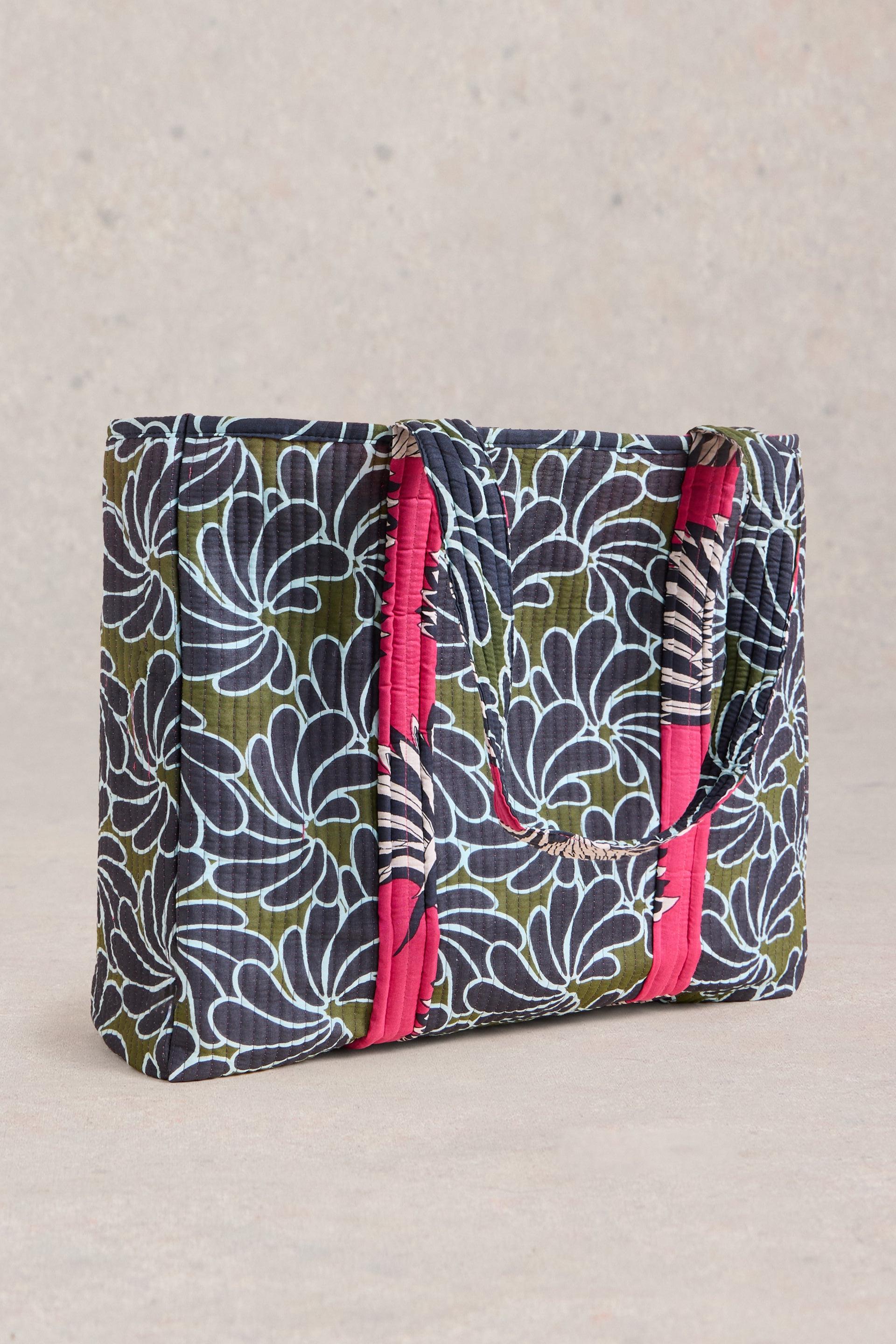 Large cotton beach bag with pink, green and navy detail on a neutral background.