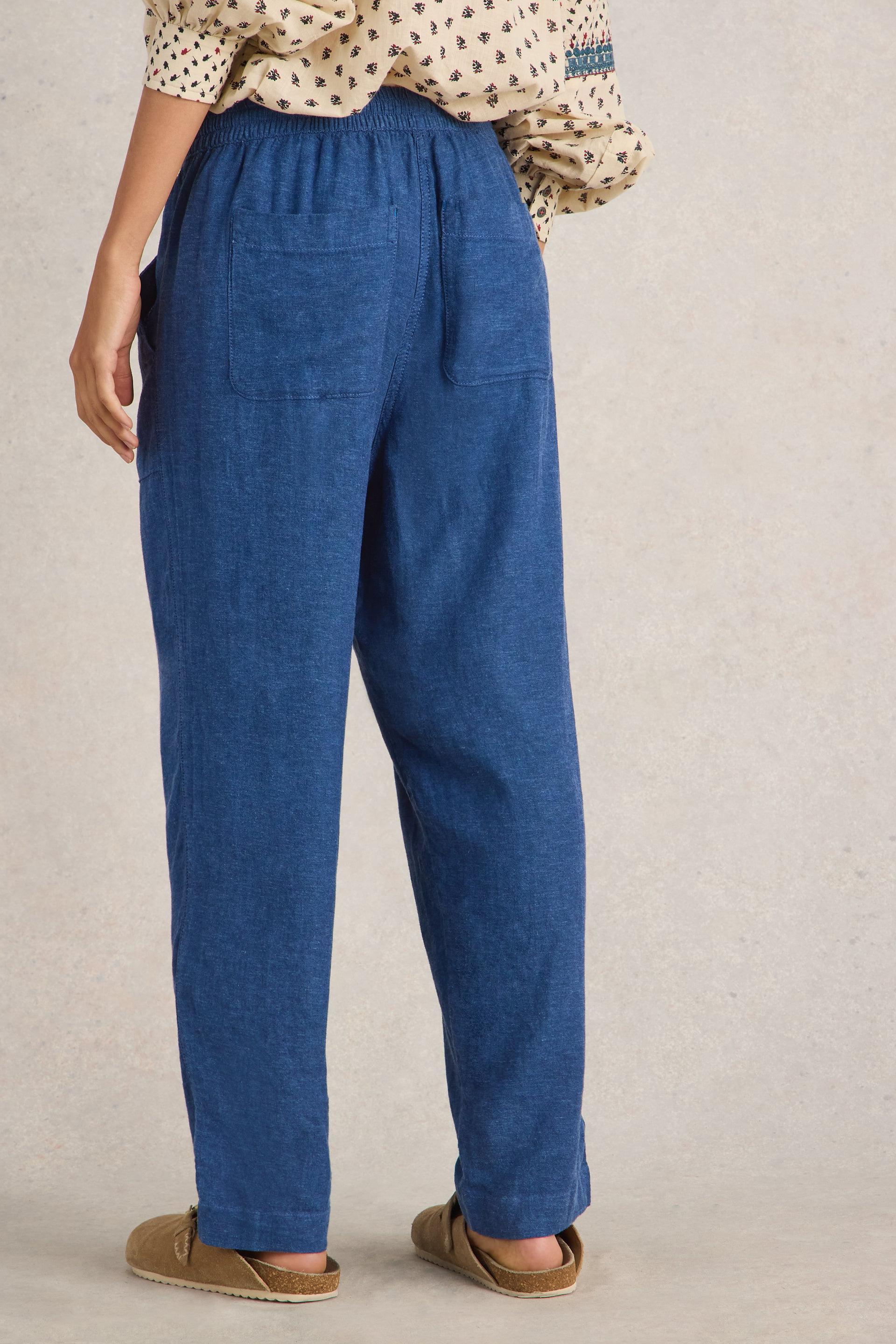 Back view of the White Stuff Elle Chambray Blue Linen Blend Trousers, highlighting the relaxed fit and two square back pockets.