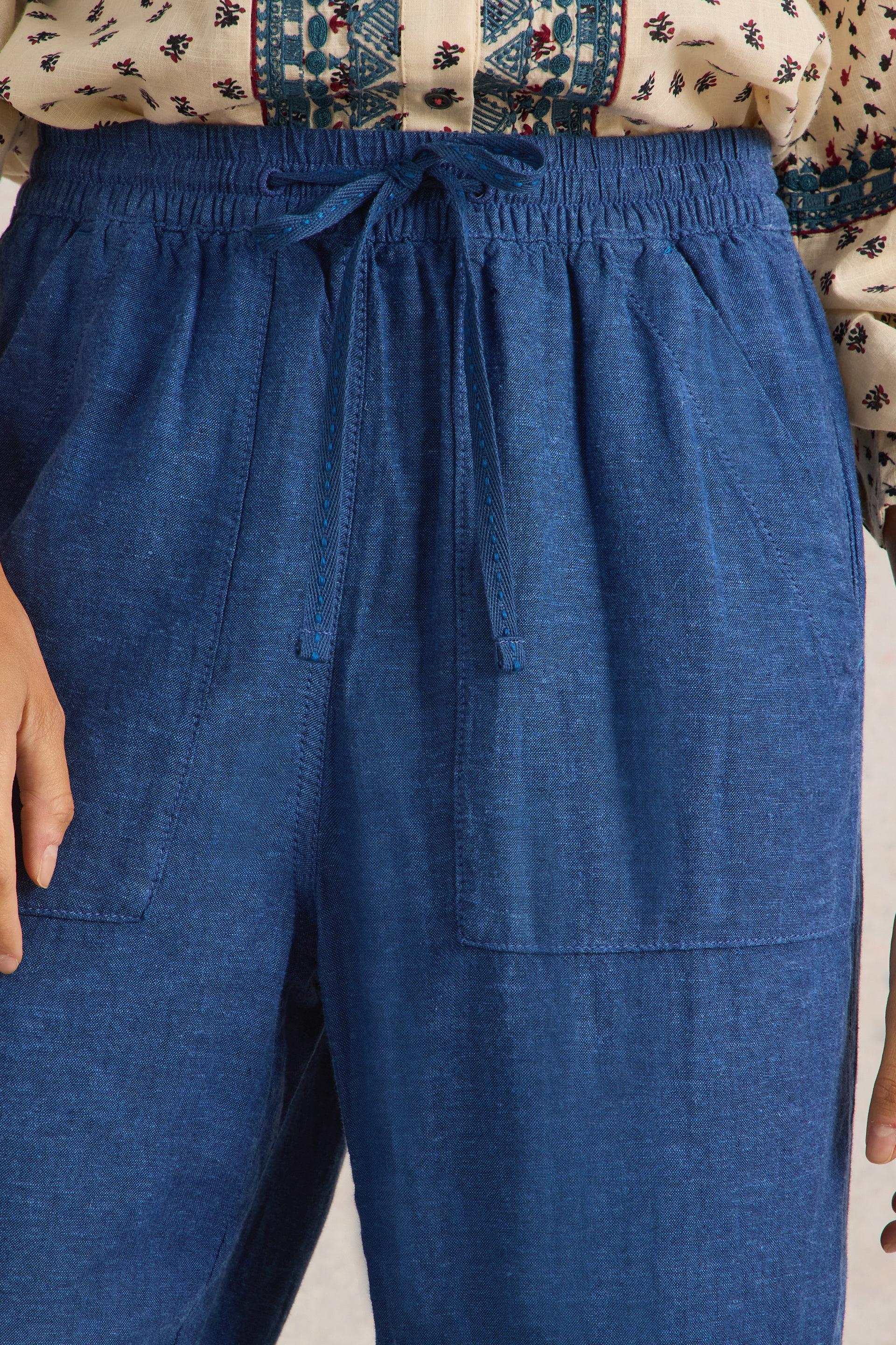 Front view of the elasticated waistband with drawcord tie on the White Stuff Elle Chambray Blue Linen Blend Trousers.