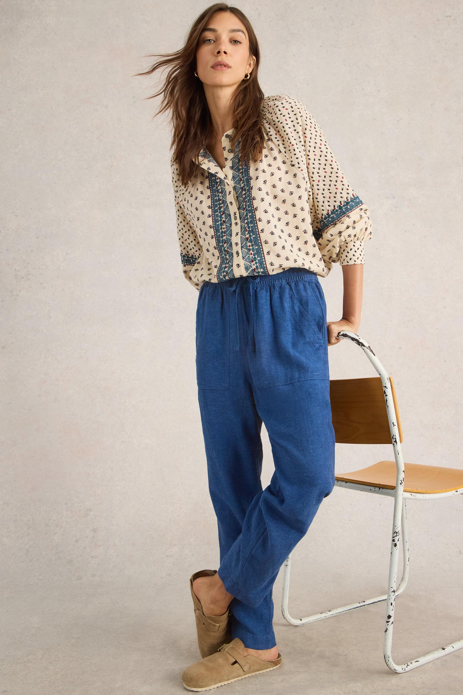 Front view of the White Stuff Elle Chambray Blue Linen Blend Trousers, highlighting the relaxed fit,, and elasticated waistband with drawcord tie.