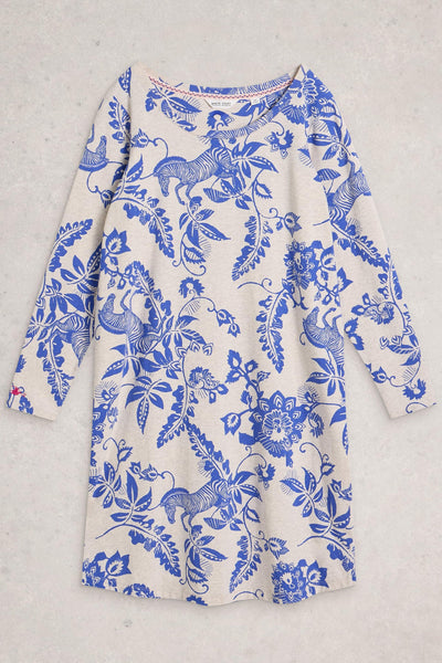 White night dress with blue floral and animal pattern on a light gray background