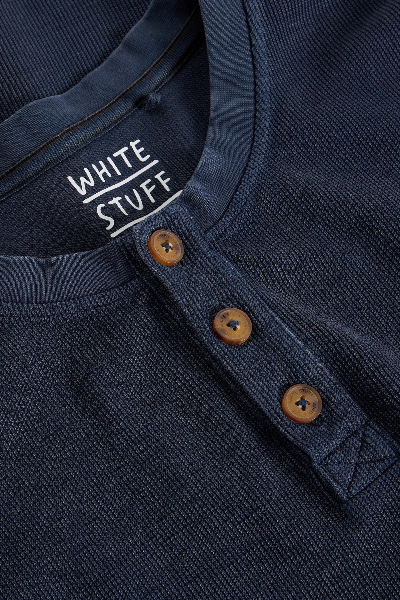 Navy blue organic cotton shirt with wooden buttons and 'White Stuff' label.