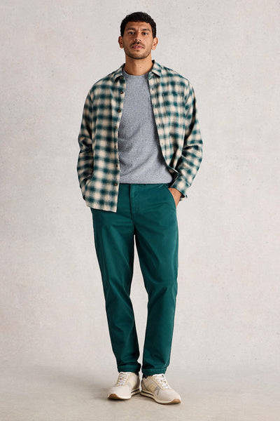Man wearing organic cotton grey t-shirt, styled with checkered shirt and dark green trousers and white sneakers