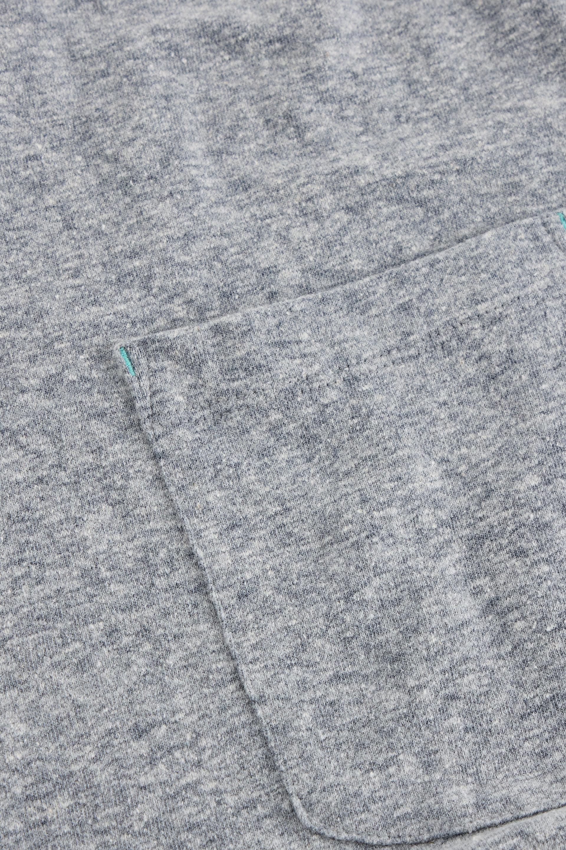 Close up of pocket on grey organic cotton t-shirt