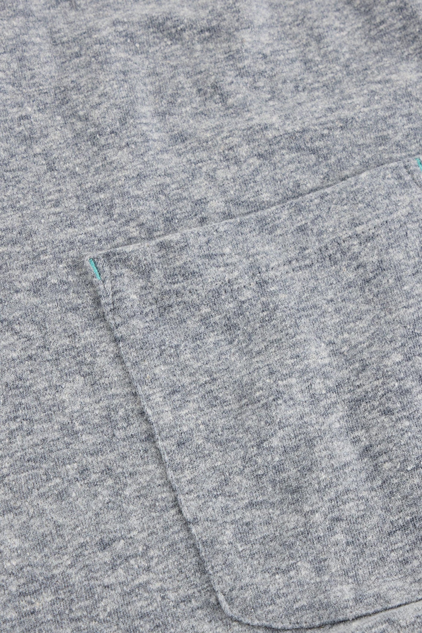 Close up of pocket on grey organic cotton t-shirt