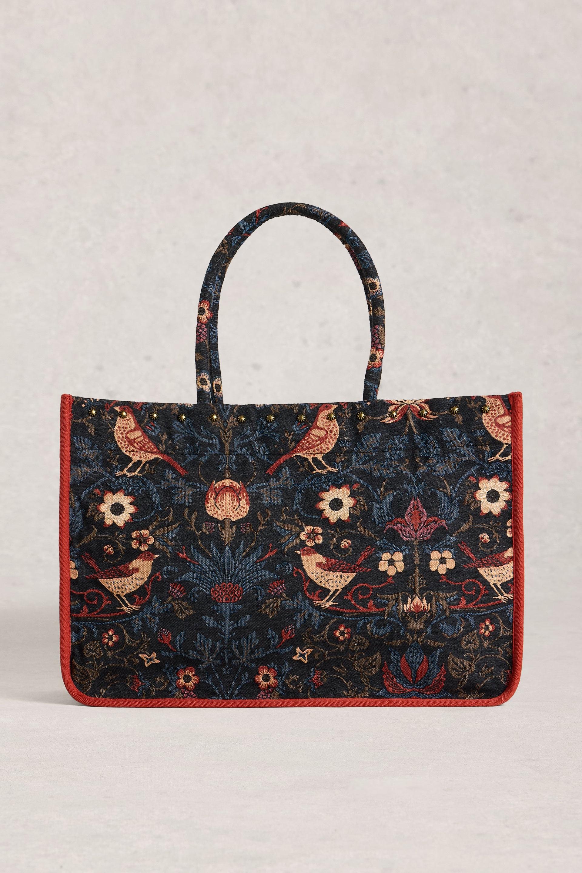 Jacquard tote with floral and bird patterns on a light gray background