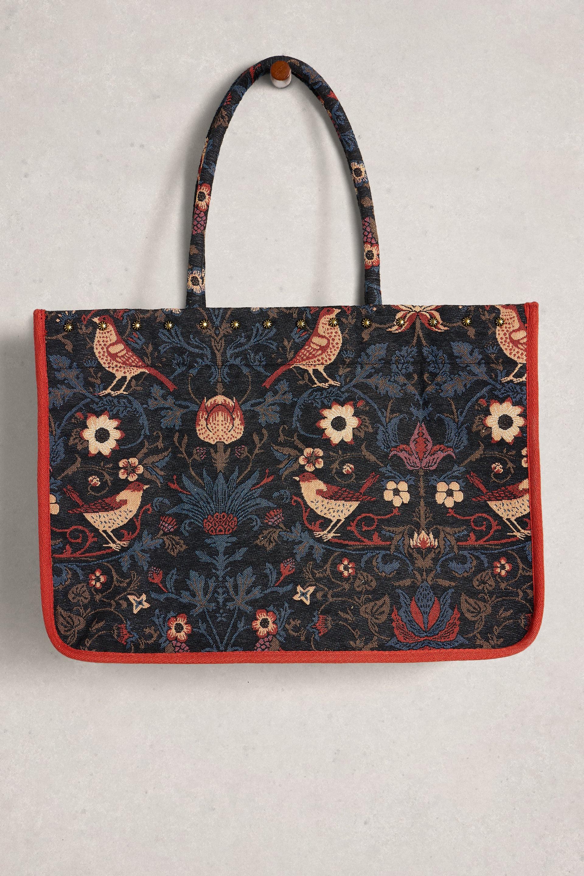 Tote bag with floral and bird pattern on a light gray background