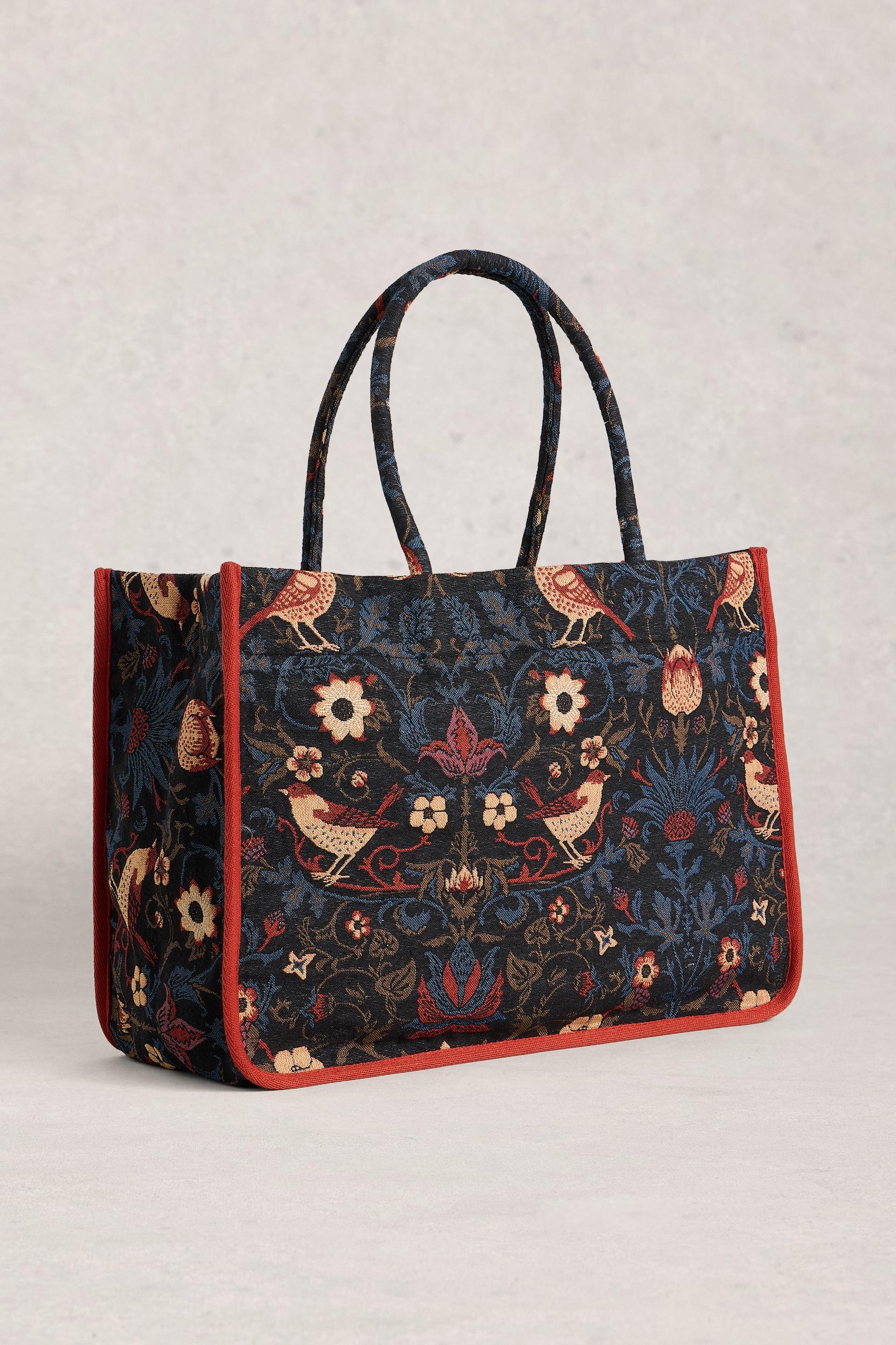Tote bag with floral and bird pattern on a light gray background