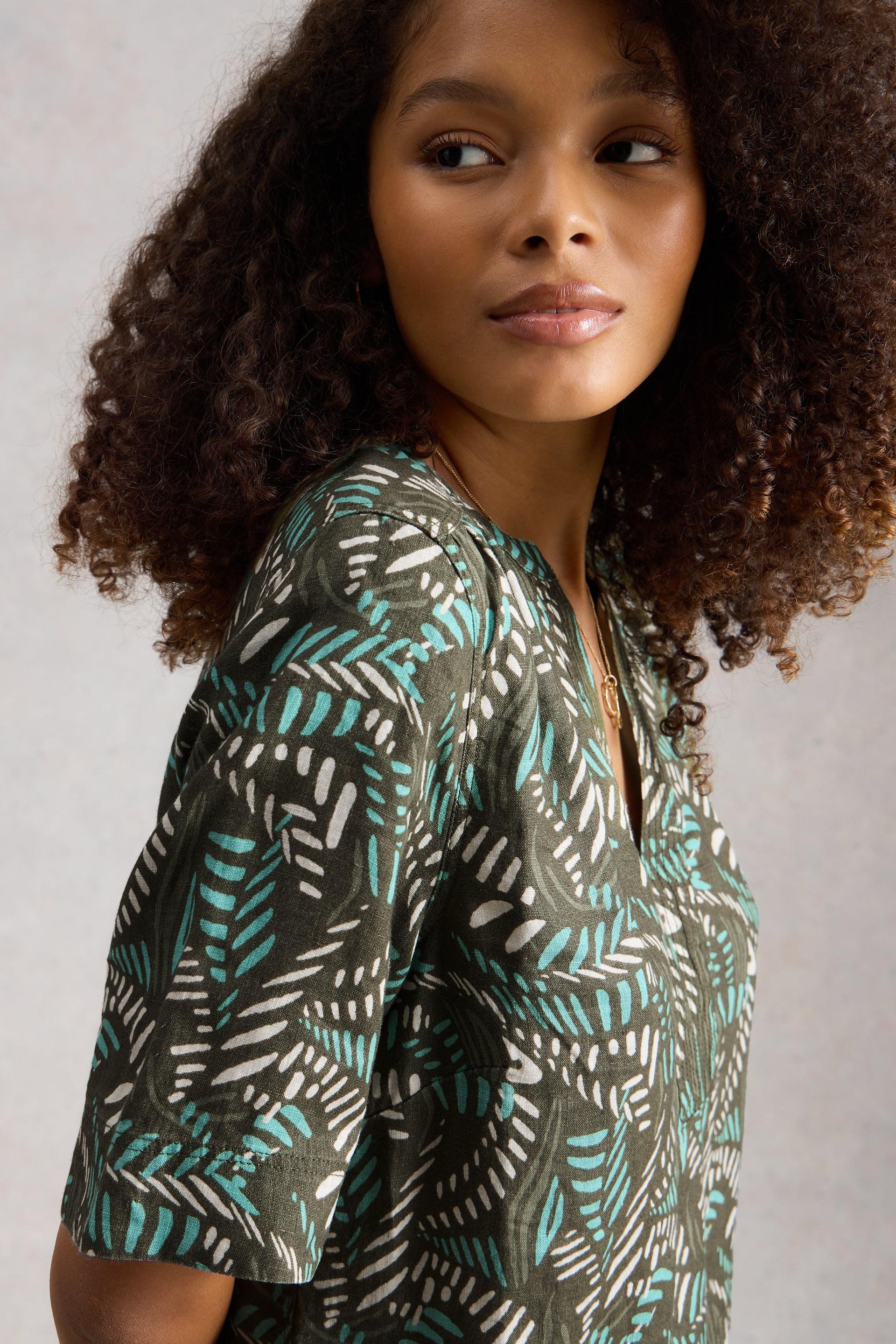 Woman wearing a patterned shirt with a neutral background