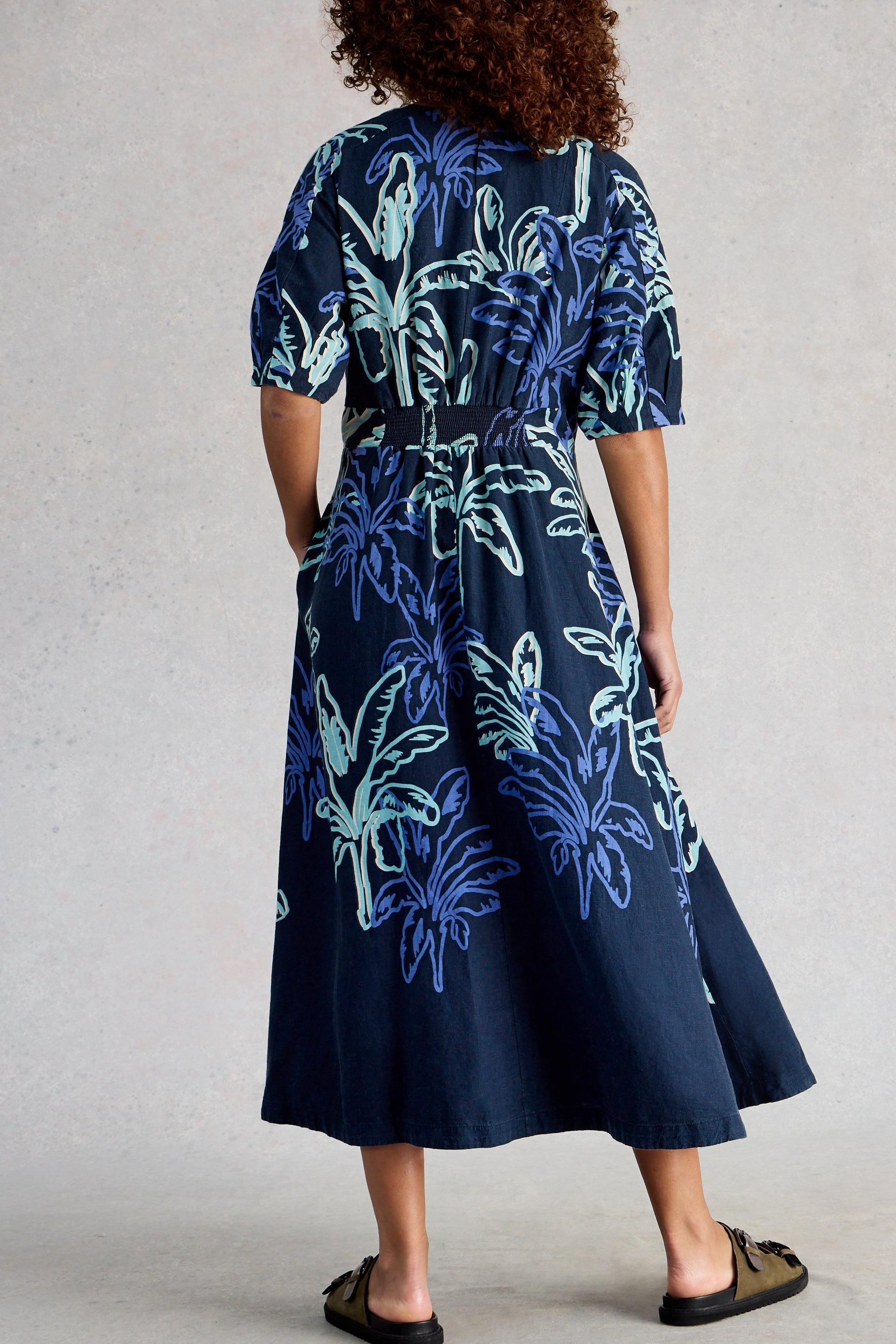 Navy dress with blue floral pattern worn by a person on a neutral background