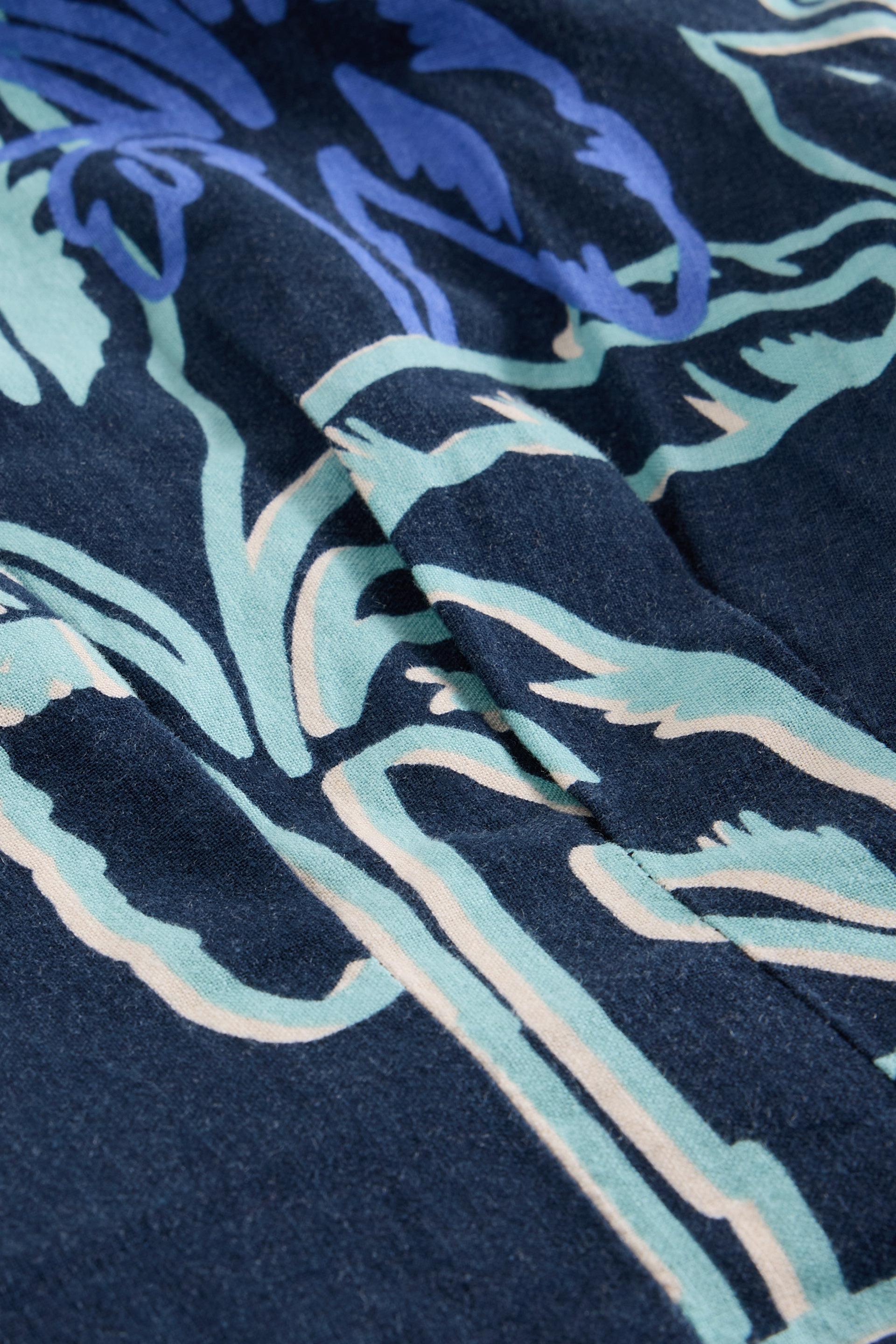 Close-up of a linen fabric with blue and green abstract pattern on a dark background