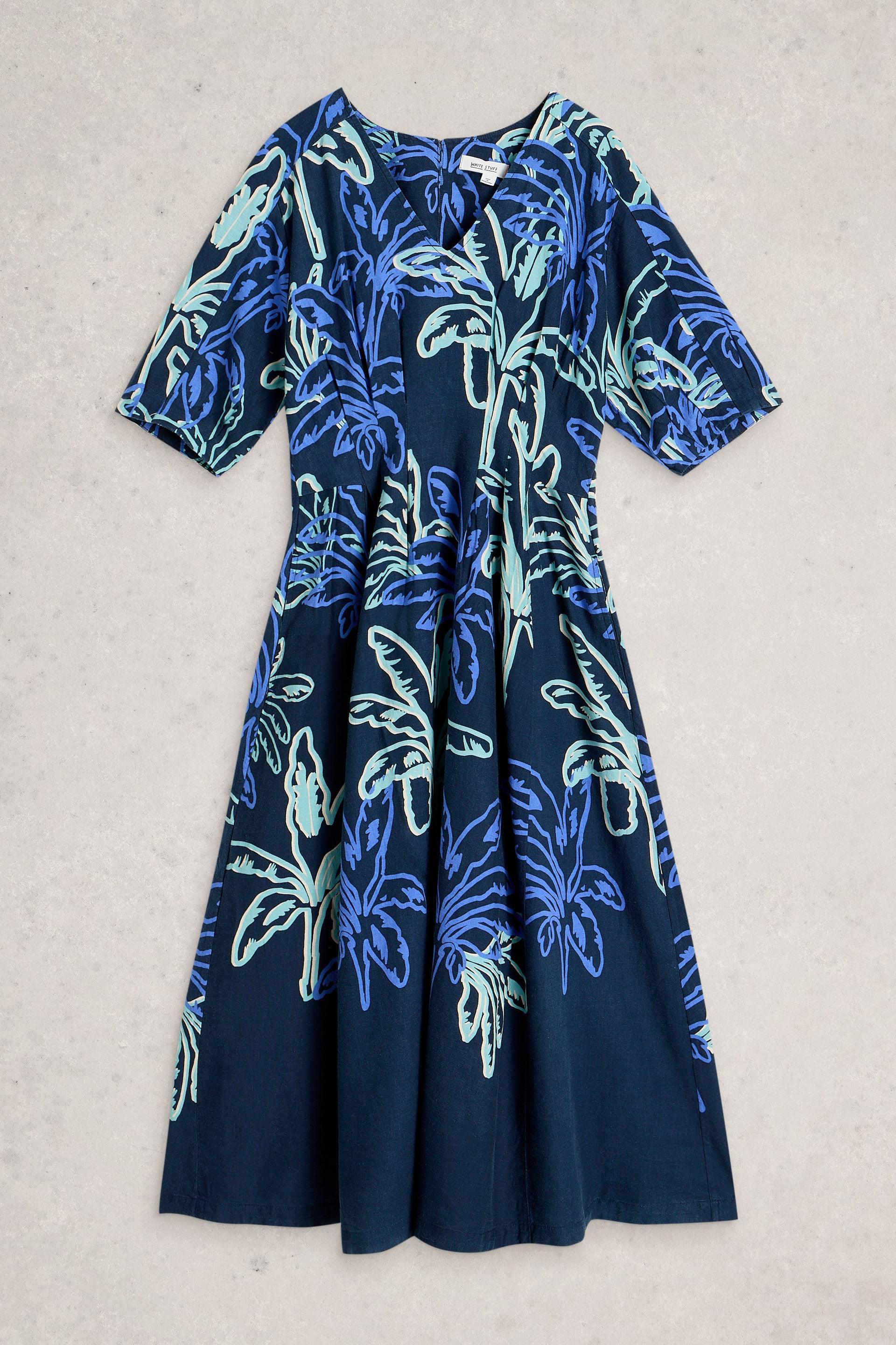 Navy blue linen dress with tropical leaf pattern on a light gray background