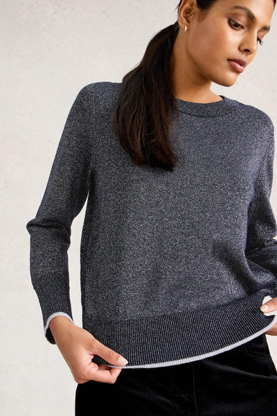 Woman wearing a dark gray organic cotton sweater against a light background