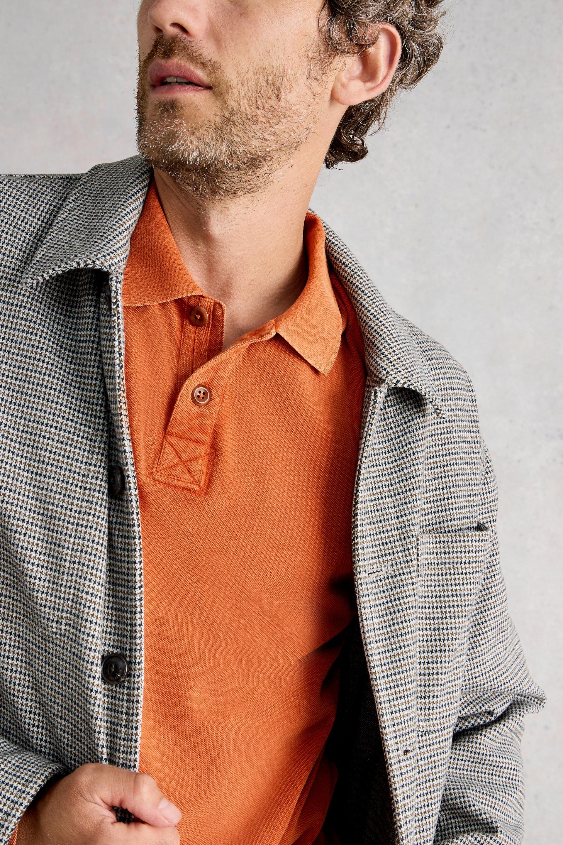 Close up of two buttons on placket layered under checkered jacket