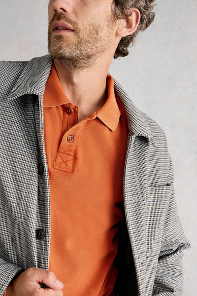 Close up of two buttons on placket layered under checkered jacket