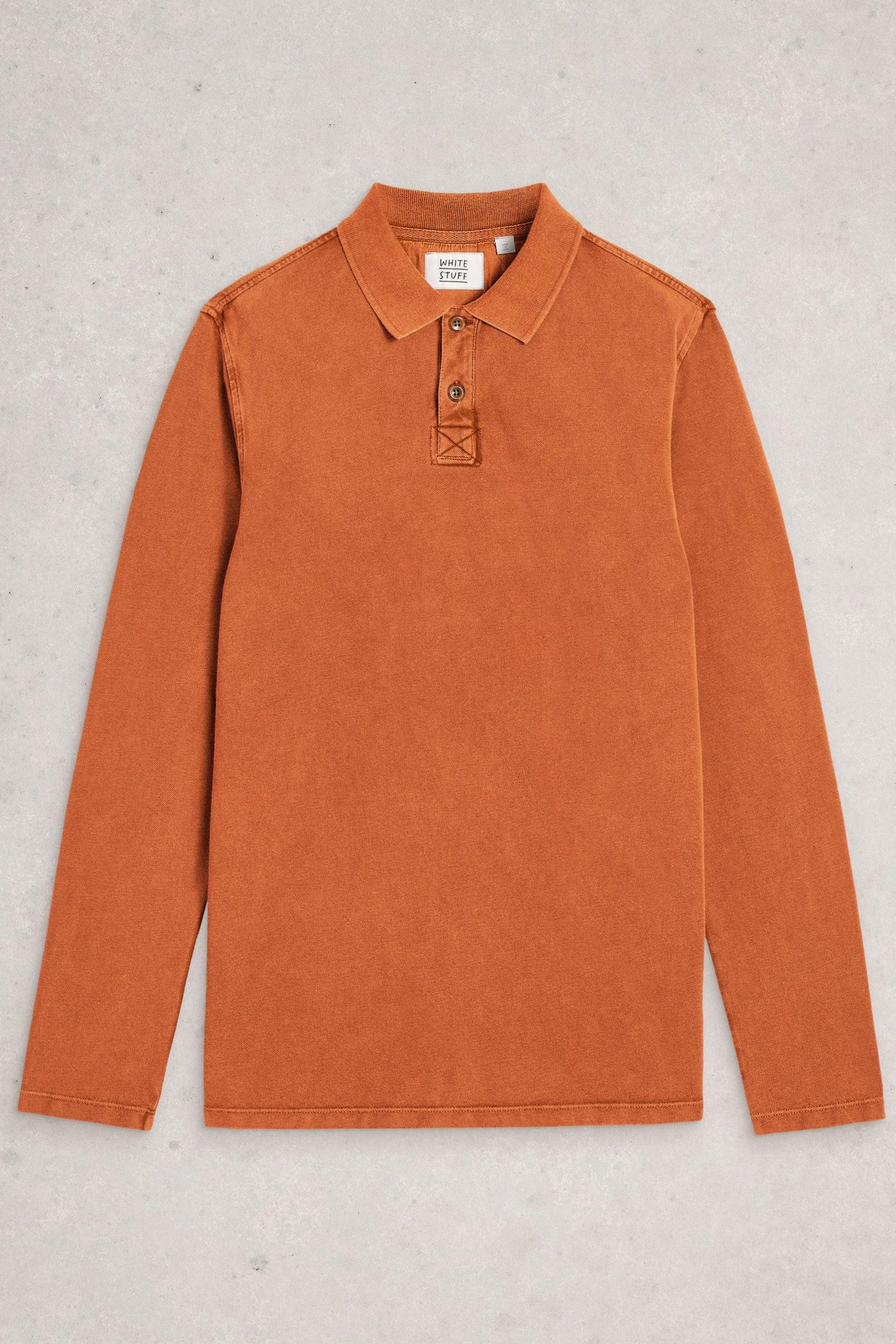 Flat lay of fairtrade cotton long sleeve orange polo on neutral background