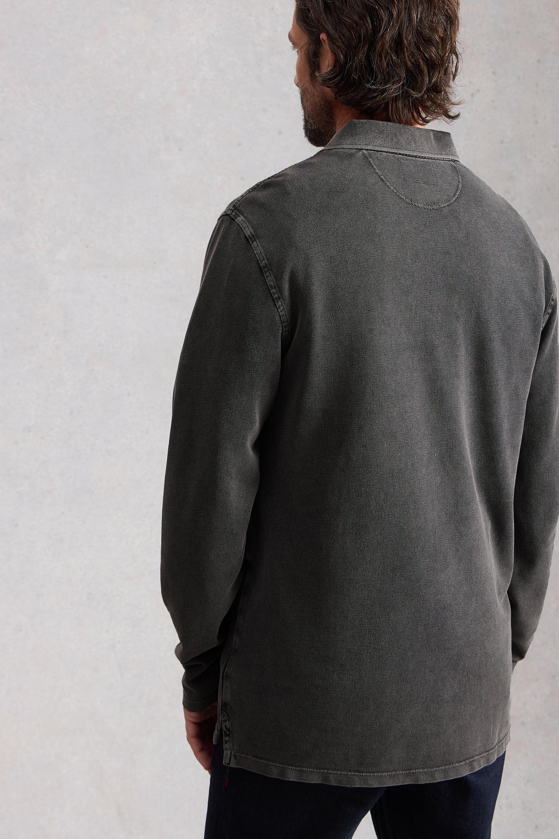 Model wearing a dark gray shirt against a light gray background