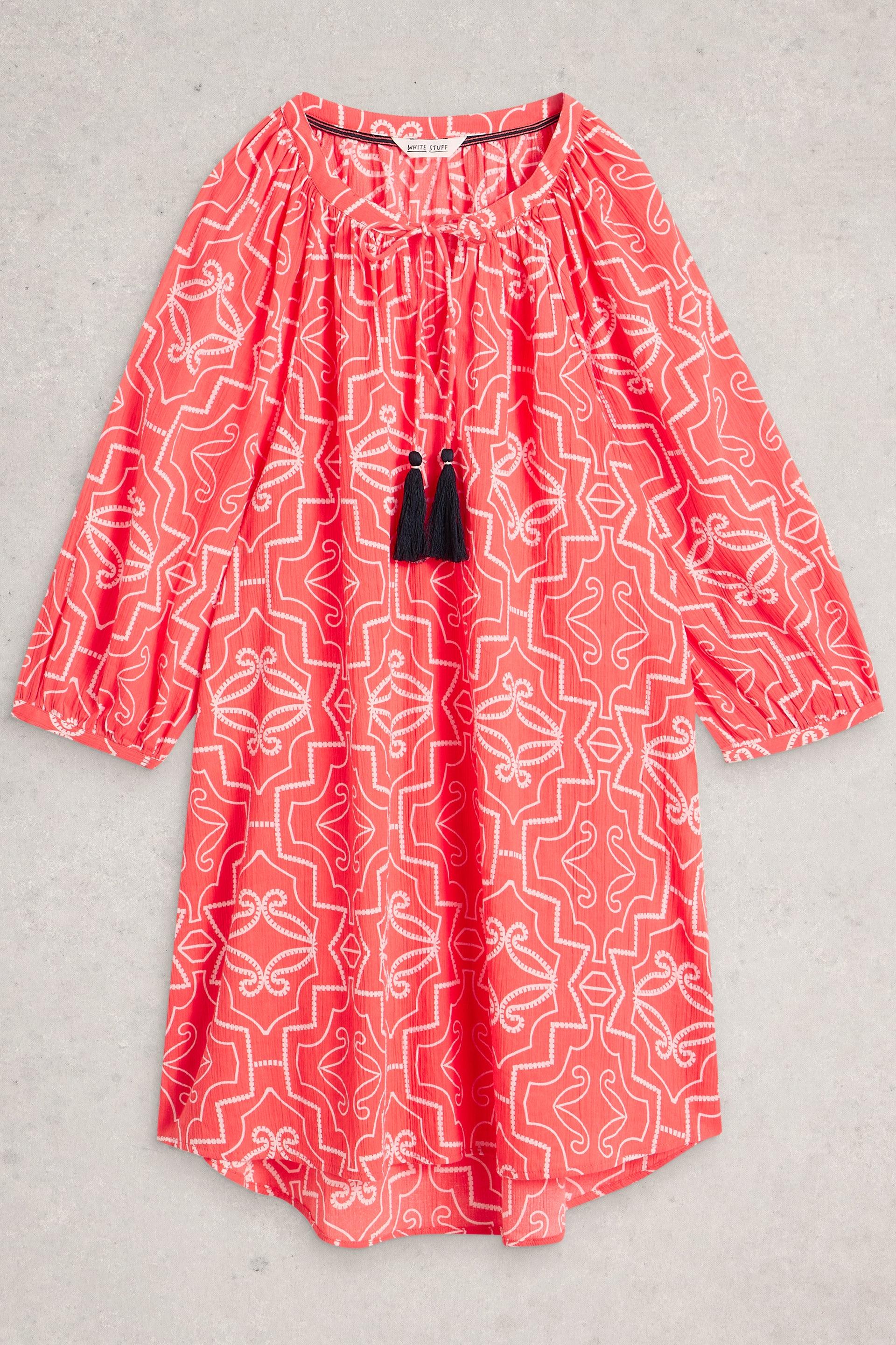 Red organic cotton coverup with white geometric pattern on a gray background