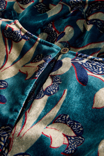 Close-up of a patterned fabric with blue, red, and beige colors.