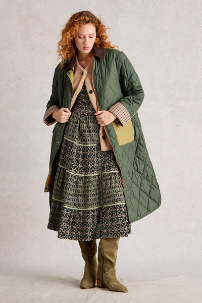 Printed tiered midi dress styled with a green long jacket and green knee-high suede boots