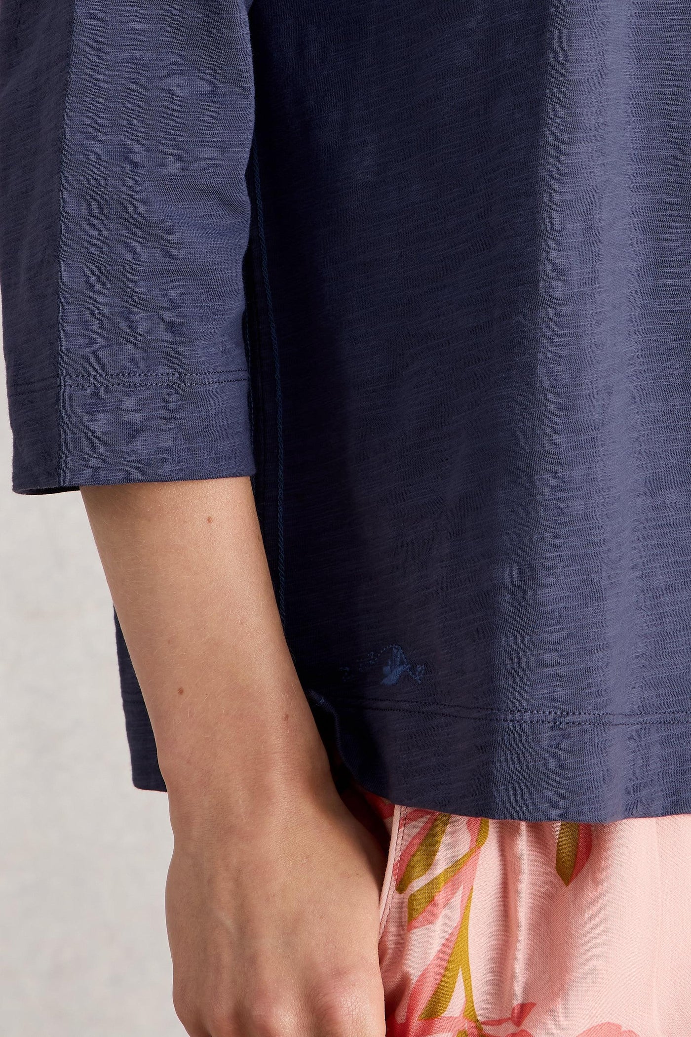 Purple organic cotton shirt with floral bottoms on a light background