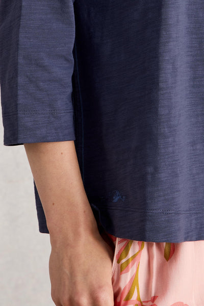 Purple organic cotton shirt with floral bottoms on a light background