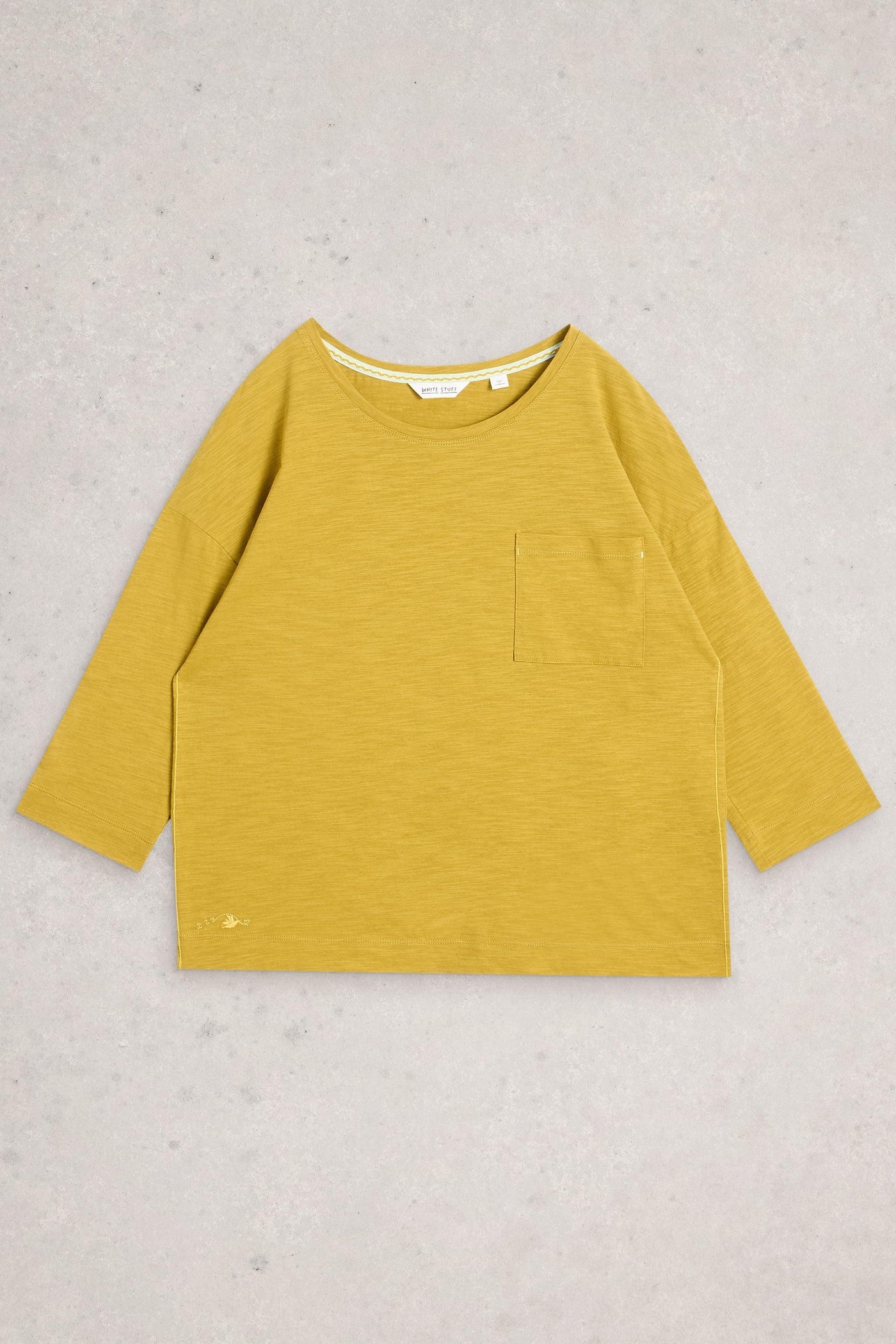 Yellow long-sleeve shirt with a pocket on a light gray background