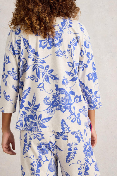 Person wearing blue floral patterned pyjamas on a plain background