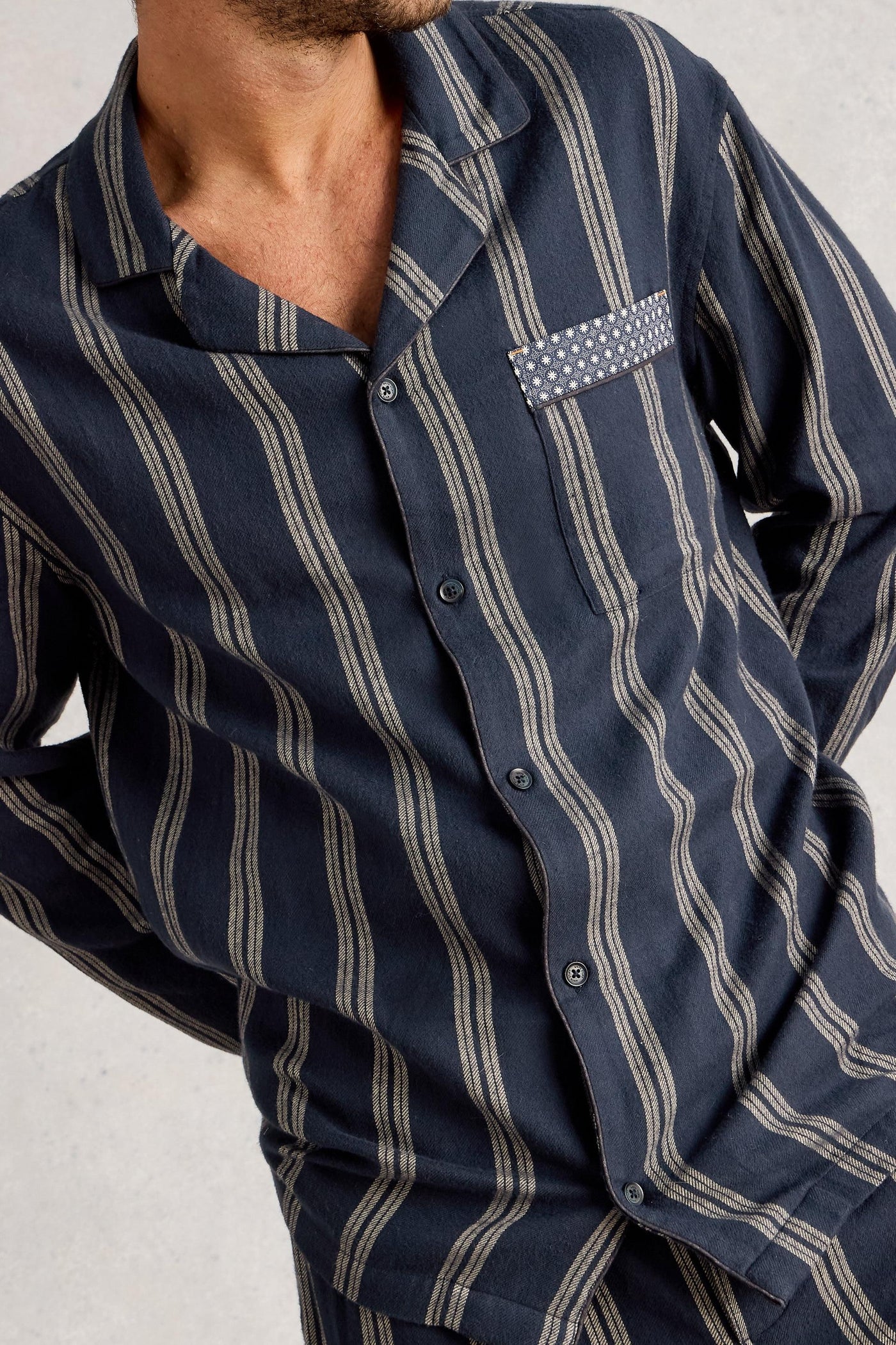Navy blue and gray striped organic cotton shirt on a plain background