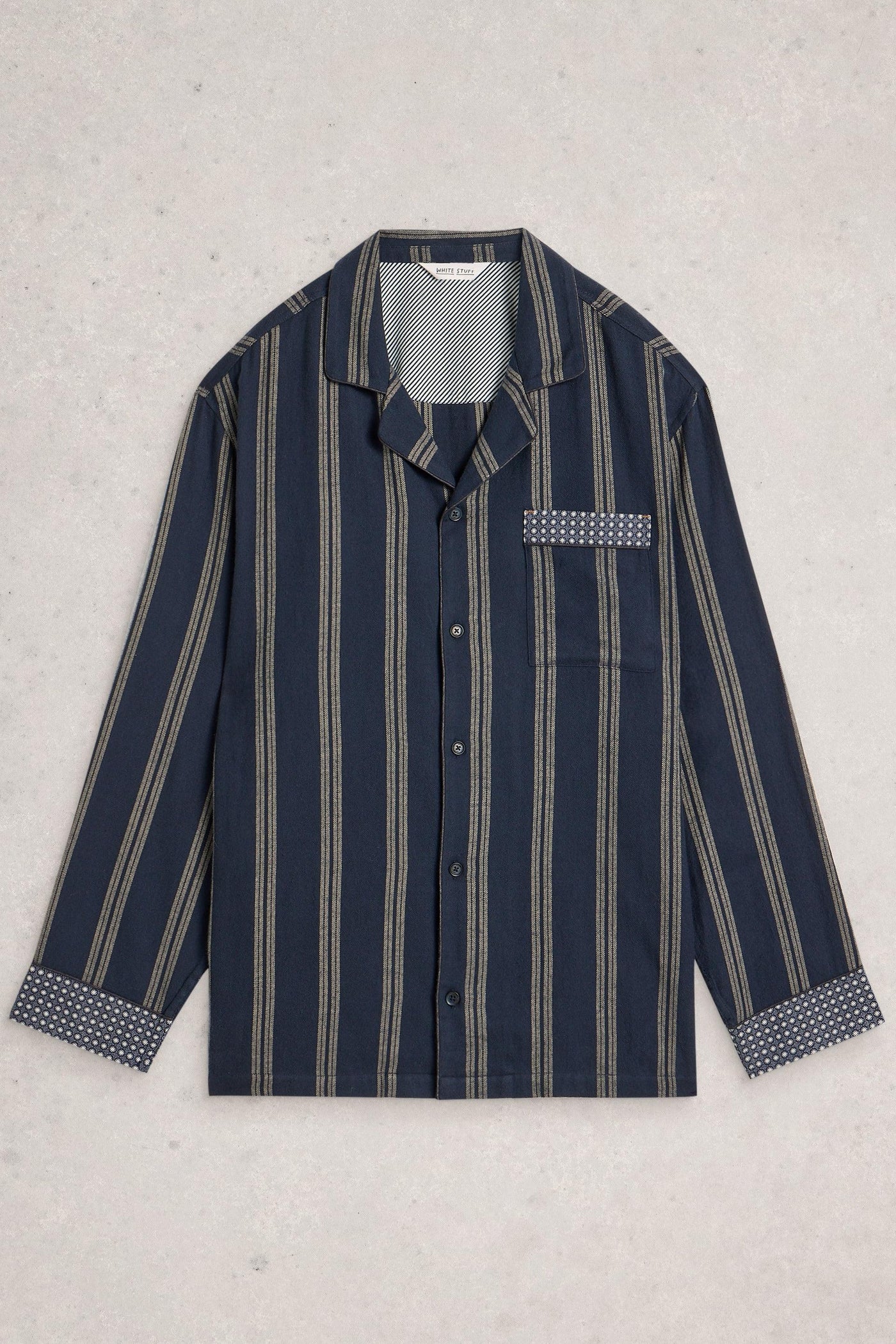 Navy striped organic cotton shirt with white buttons on a light gray background