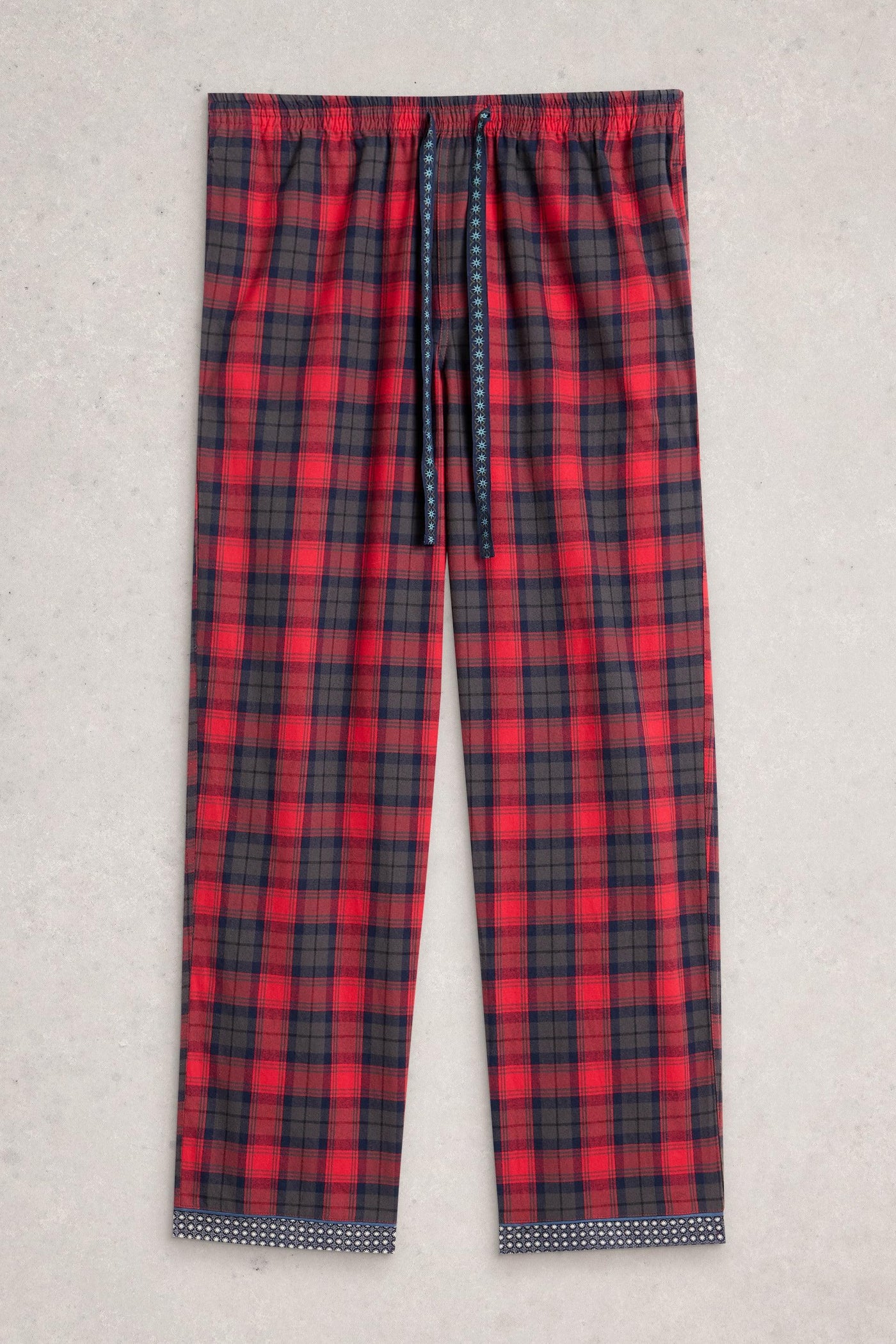 Red and black plaid pajama pants on a light gray background
