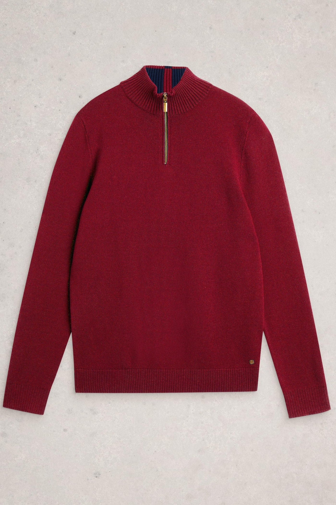 Flat lay of red merino wool knit with quarter-zip neck