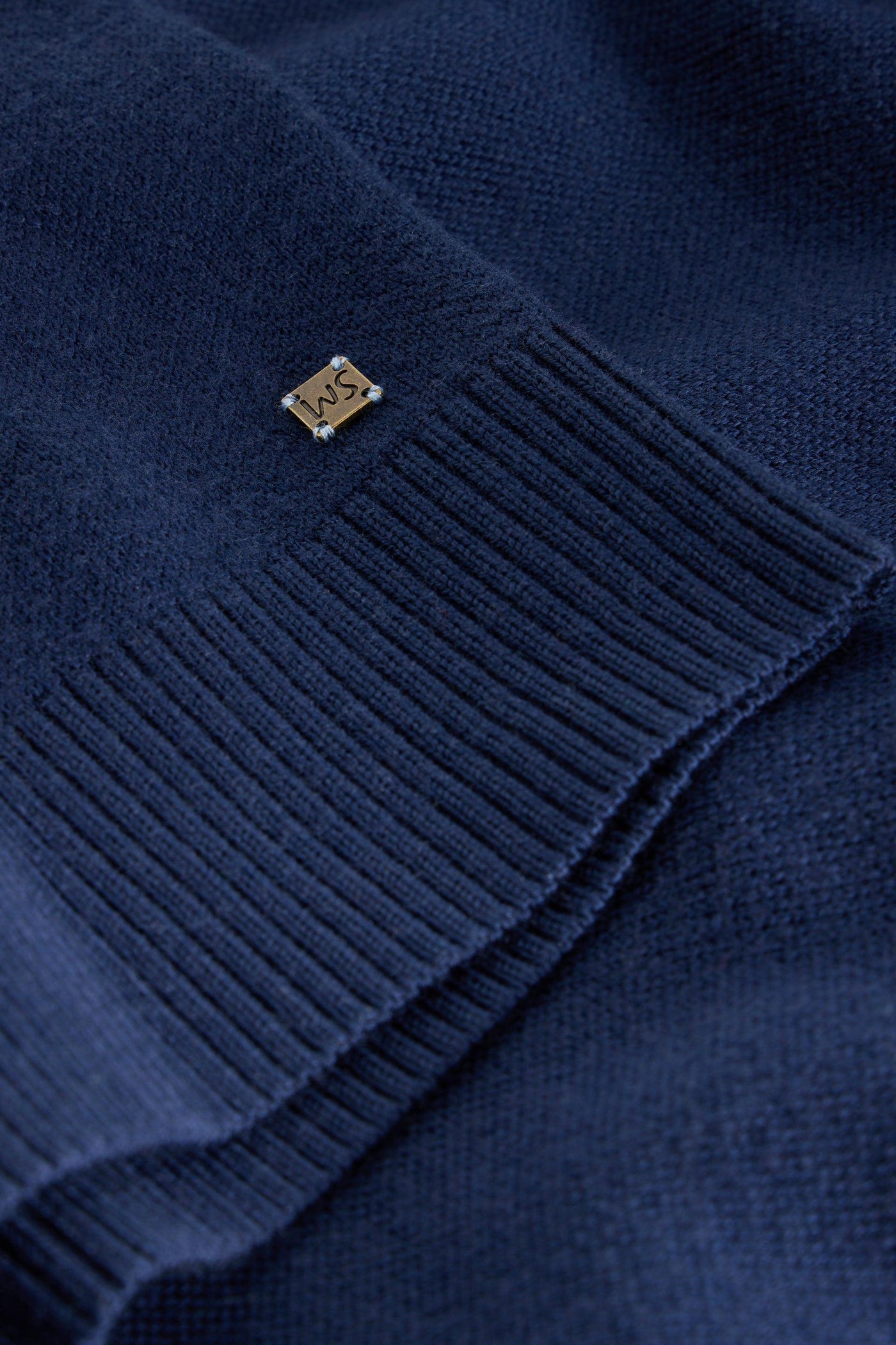 Close up of ribbed sleeves and White Stuff logo on merino long sleeve knit