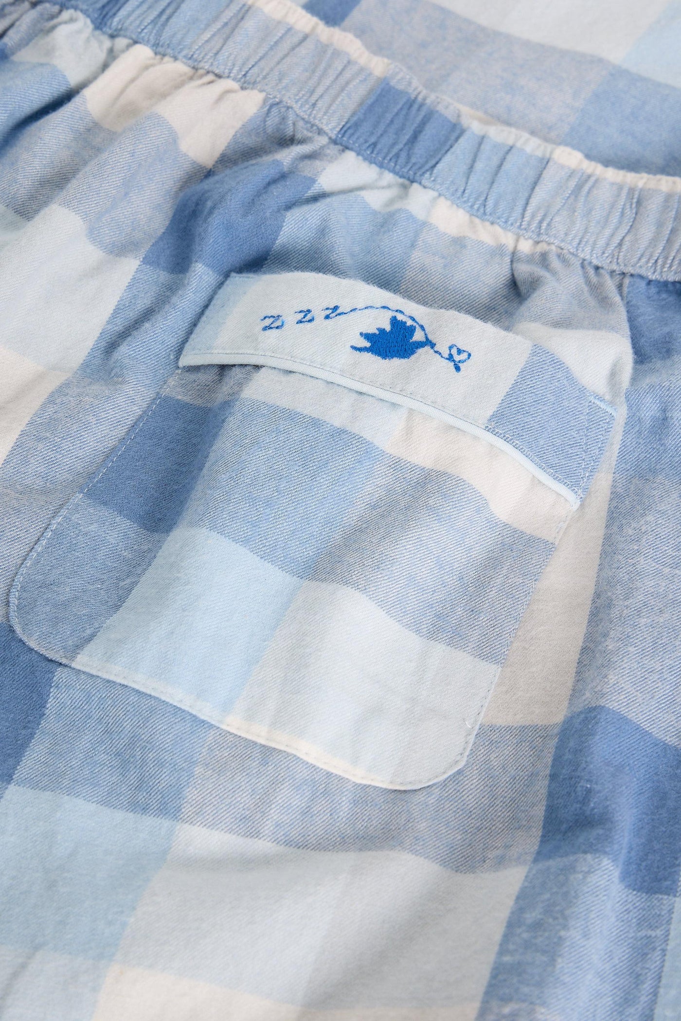 Close-up of blue and white striped fabric with a brand label.