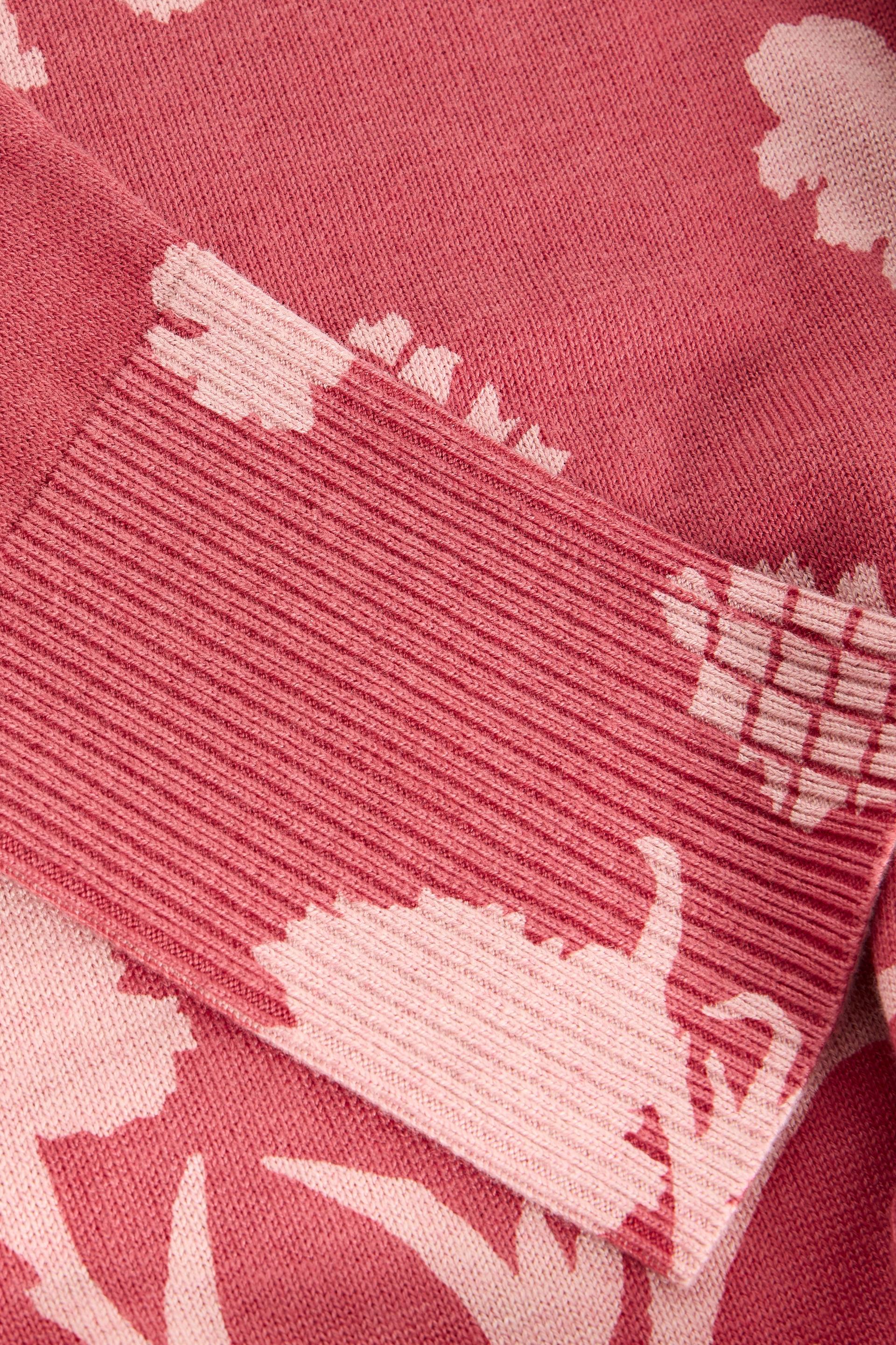 Close-up of pink ribbed cuffs with white floral patterns on a matching fabric background