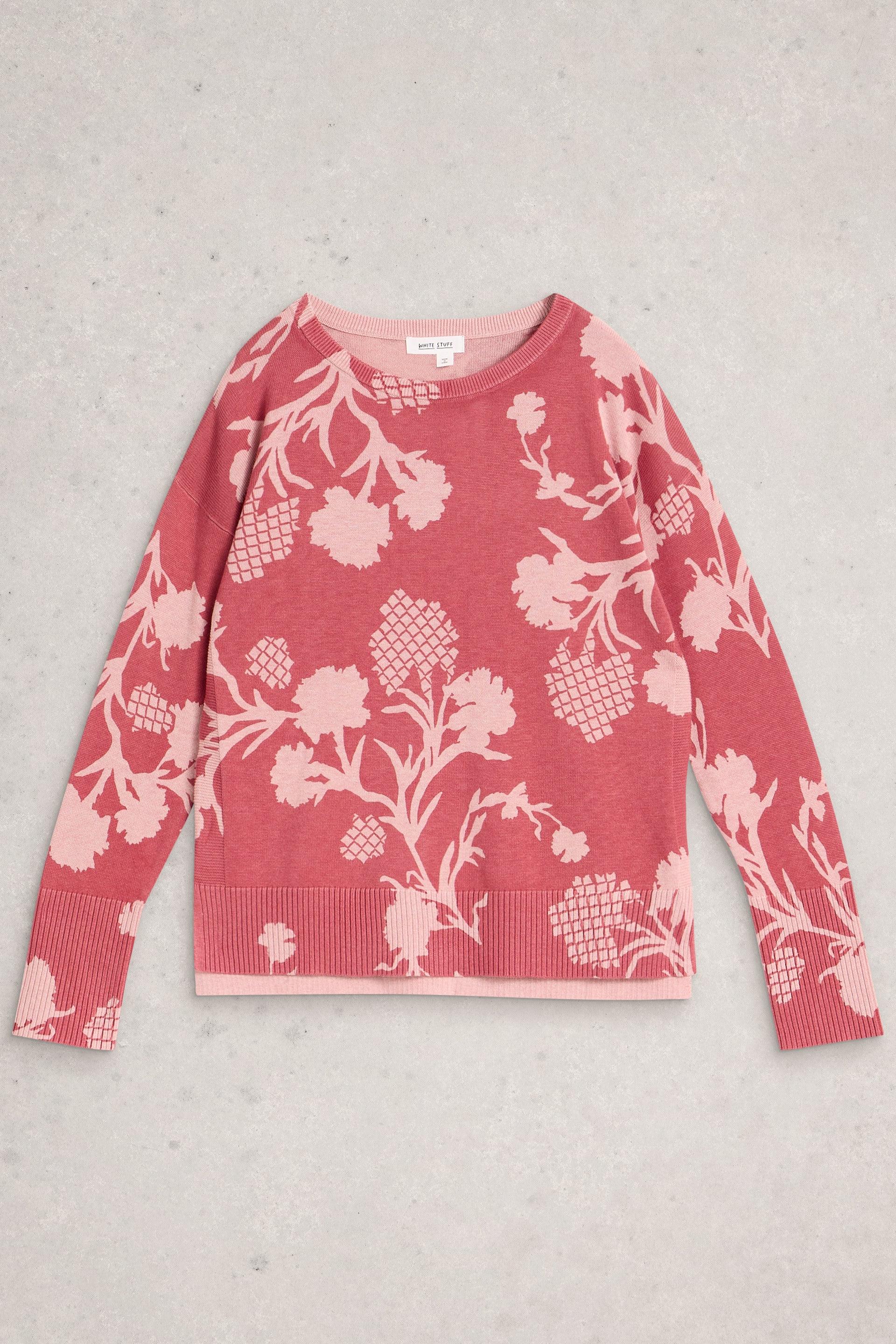 Pink organic cotton sweater with white floral pattern on a light gray background