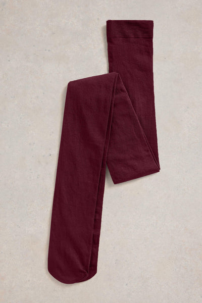 Pair of burgundy tights on a beige textured surface