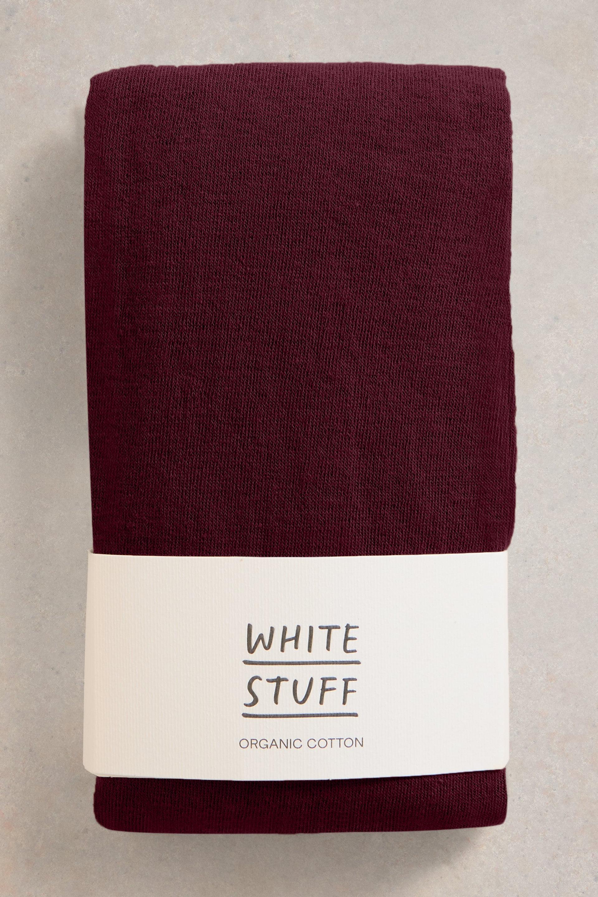 Folded burgundy tights with a 'White Stuff' label on a light background