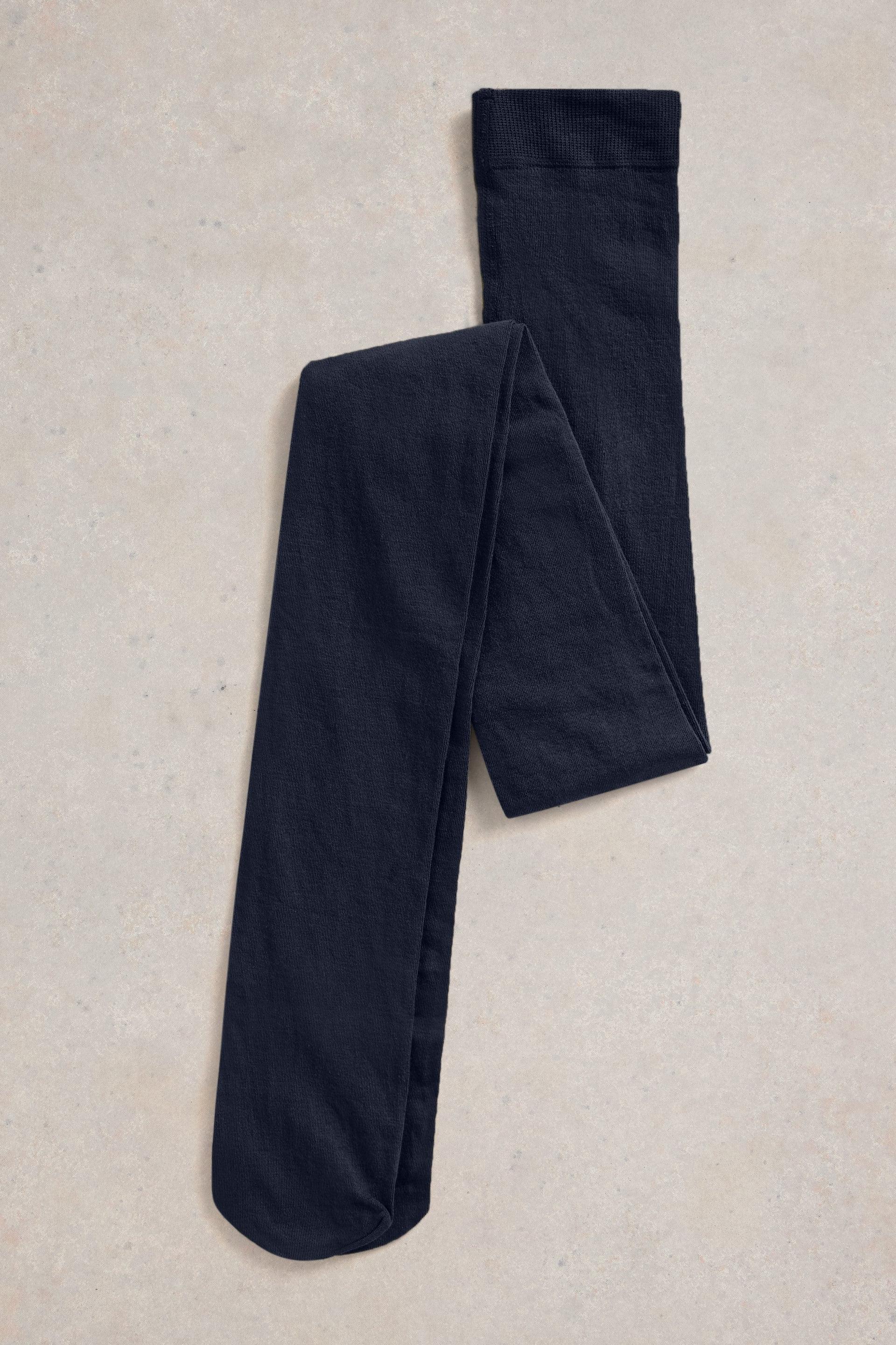 Organic cotton navy tights on a beige textured surface