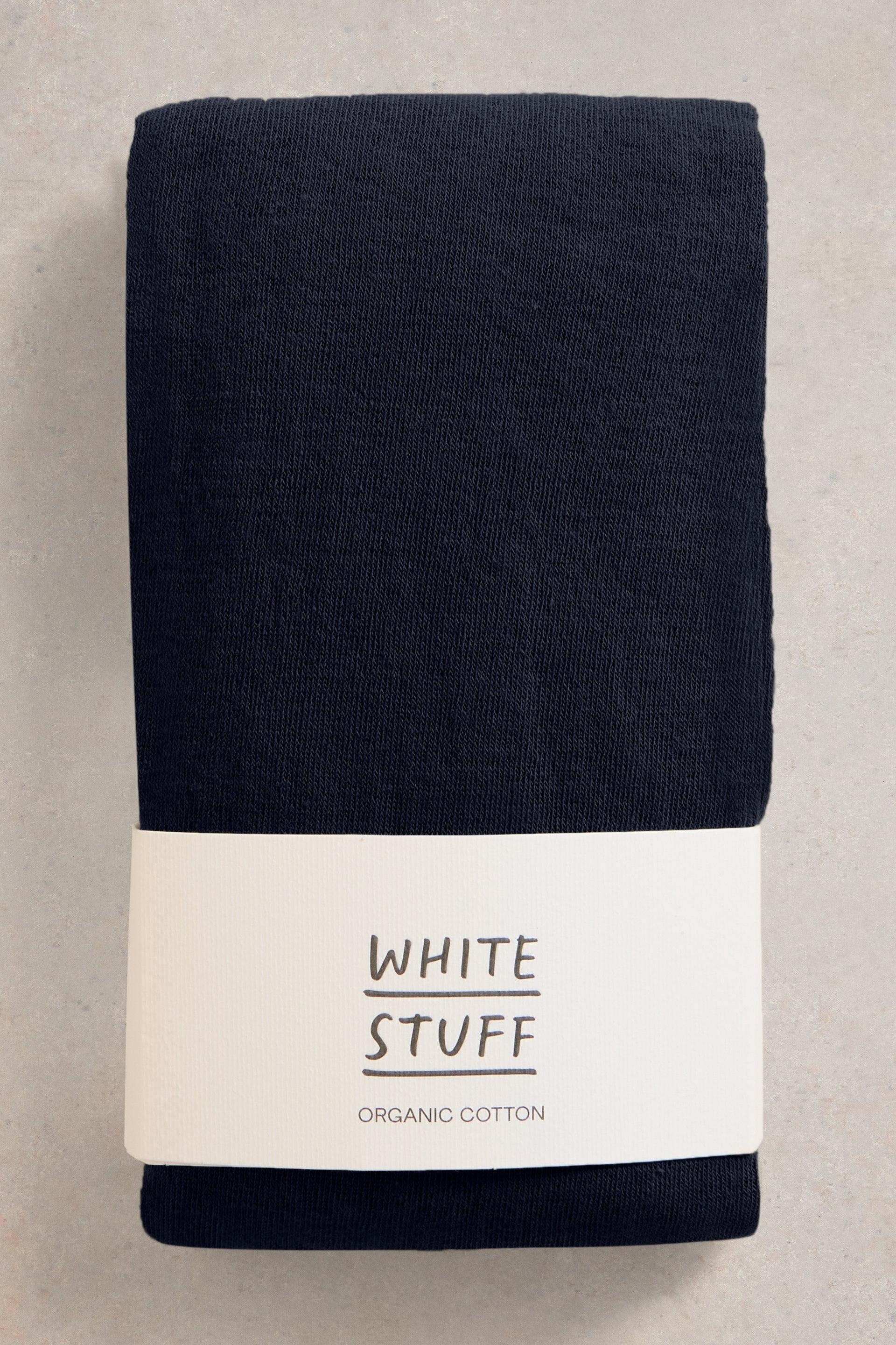 Organic cotton navy tights with a white label on a beige background